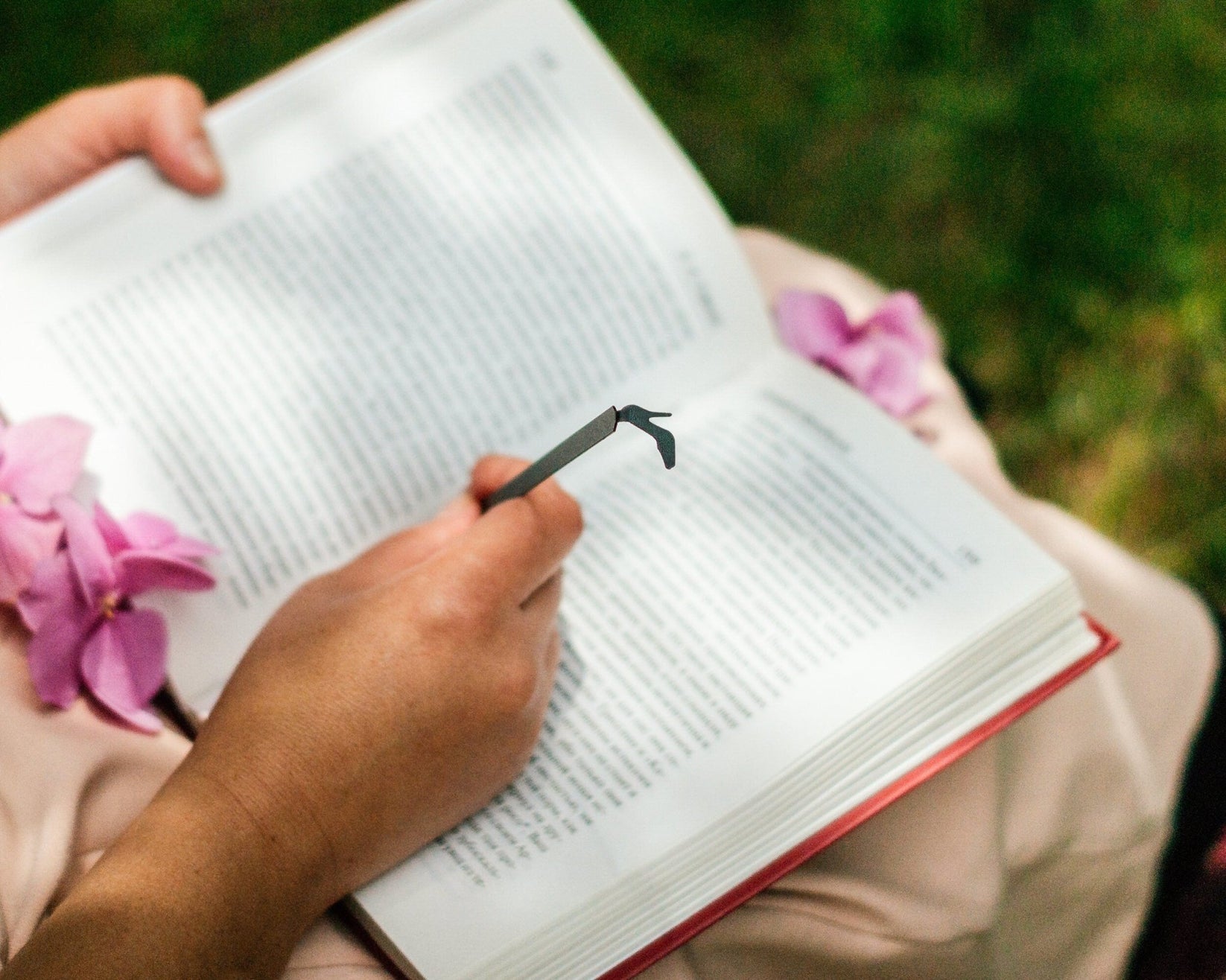 High Heel Shoe metal bookmark held up beside an open book