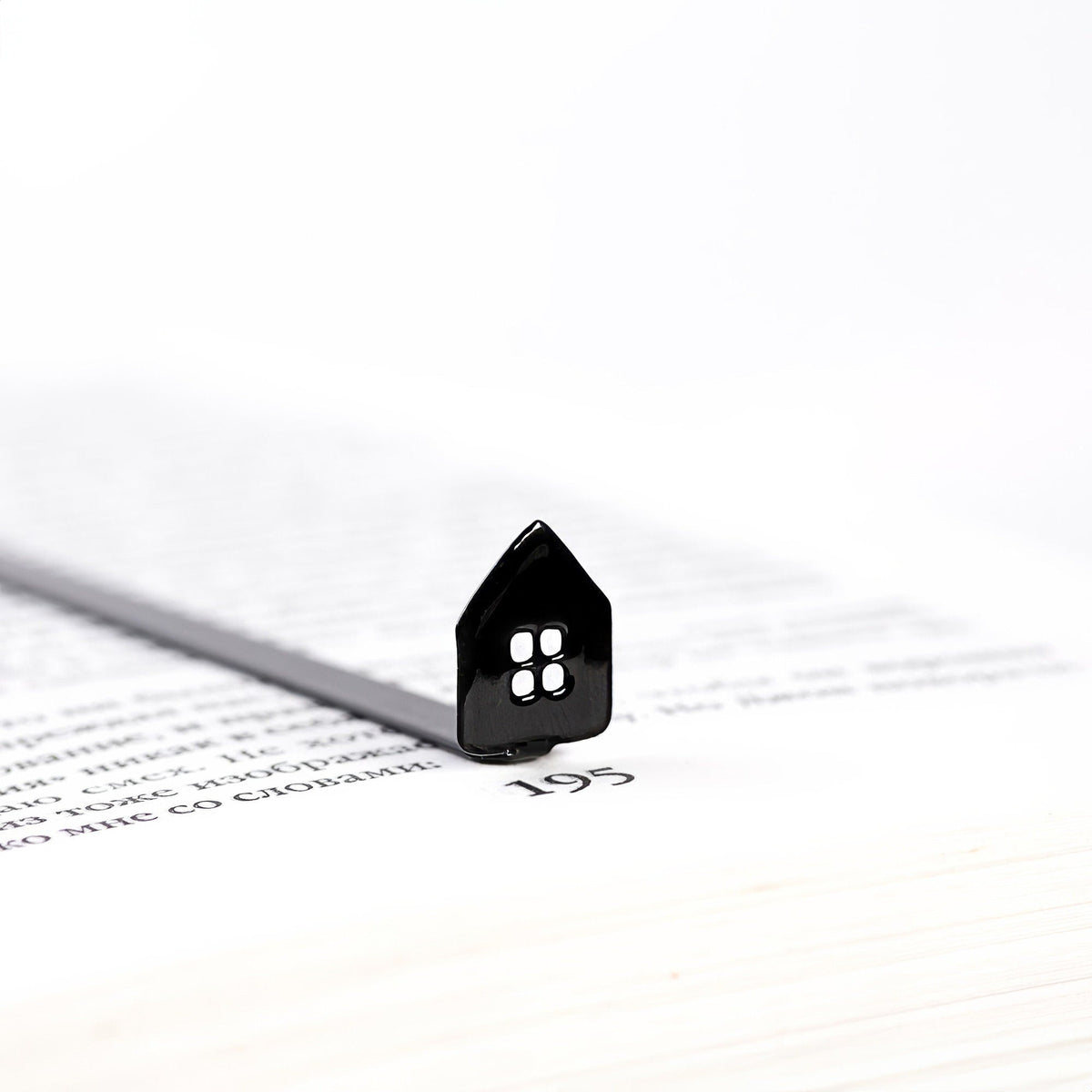 Home Sweet Home metal bookmark marking a page in an open book