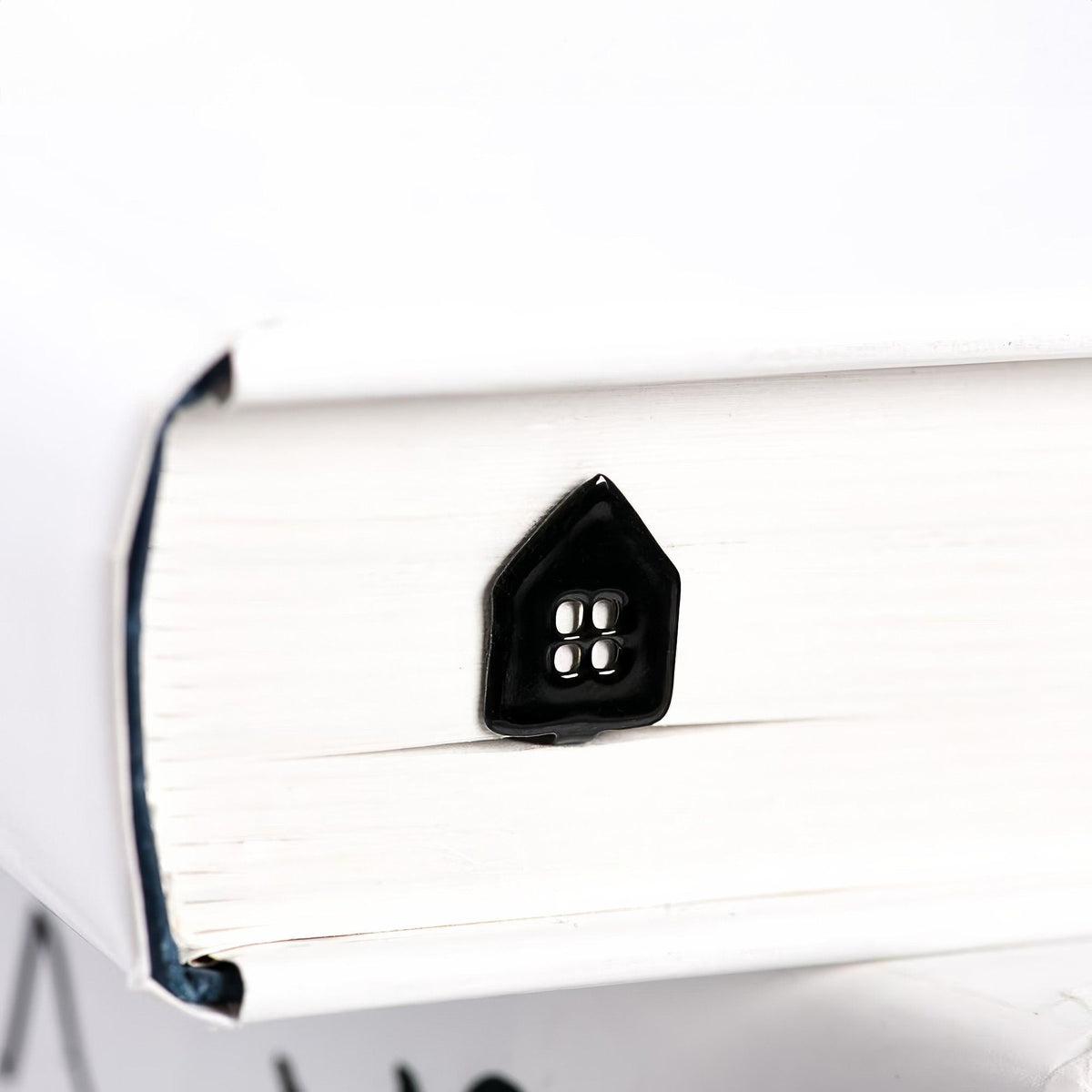 Home Sweet Home metal bookmark lying across the pages of an open book