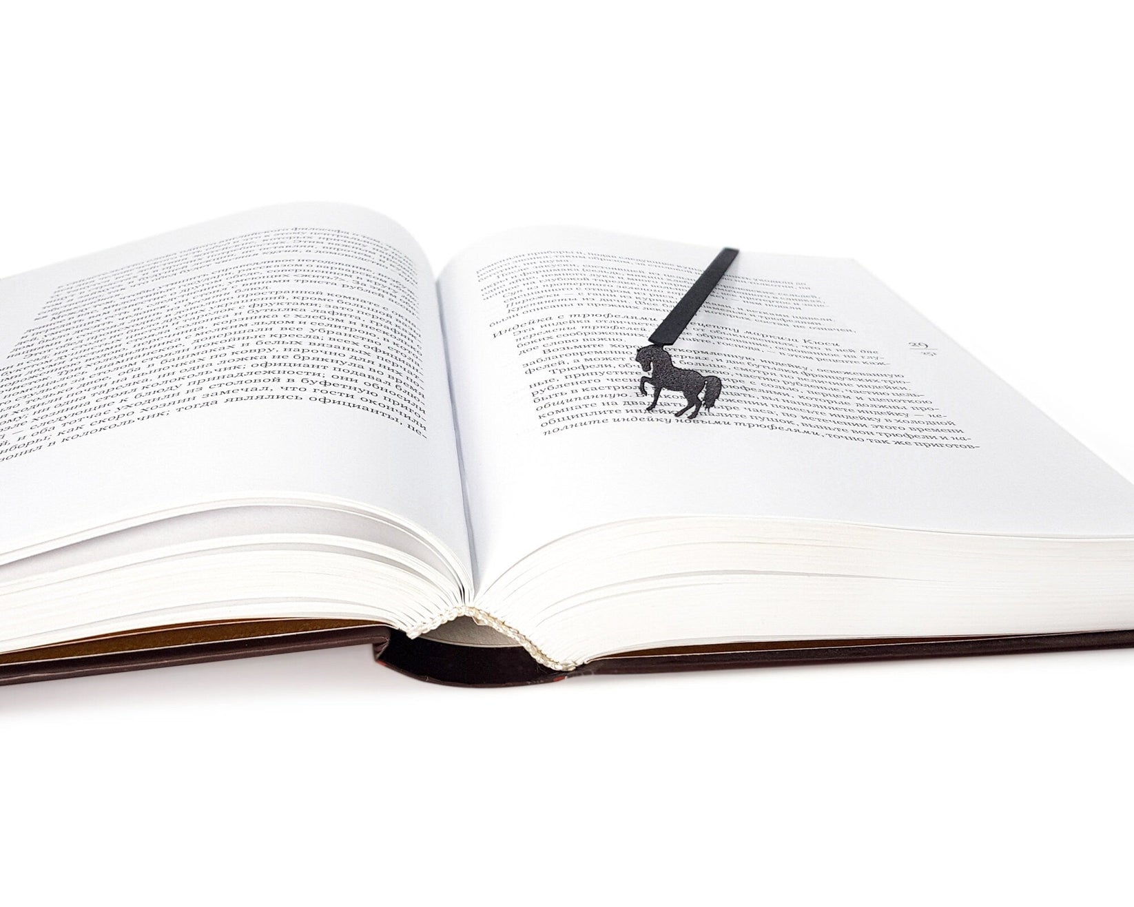 Horse metal bookmark marking a page in an open book
