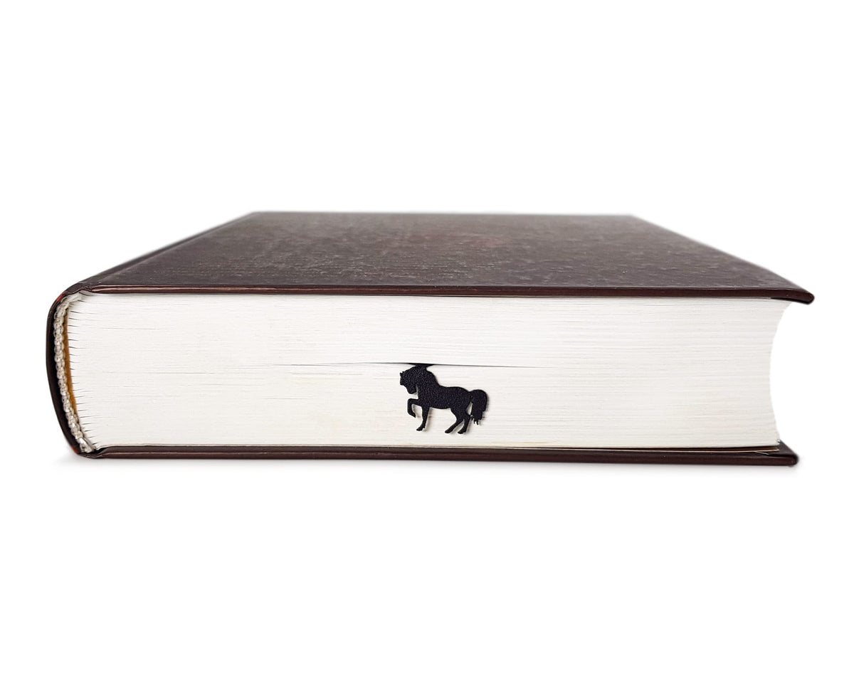 Horse metal bookmark in a closed book, only its top showing above the pages