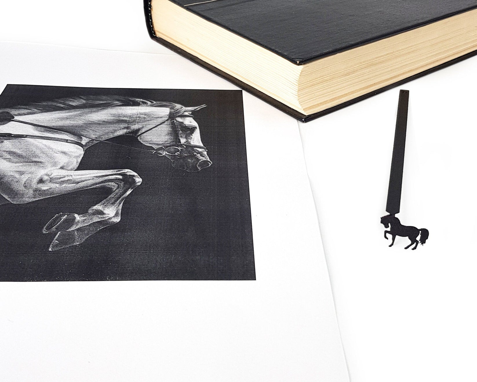 Horse metal bookmark placed on a colour illustration
