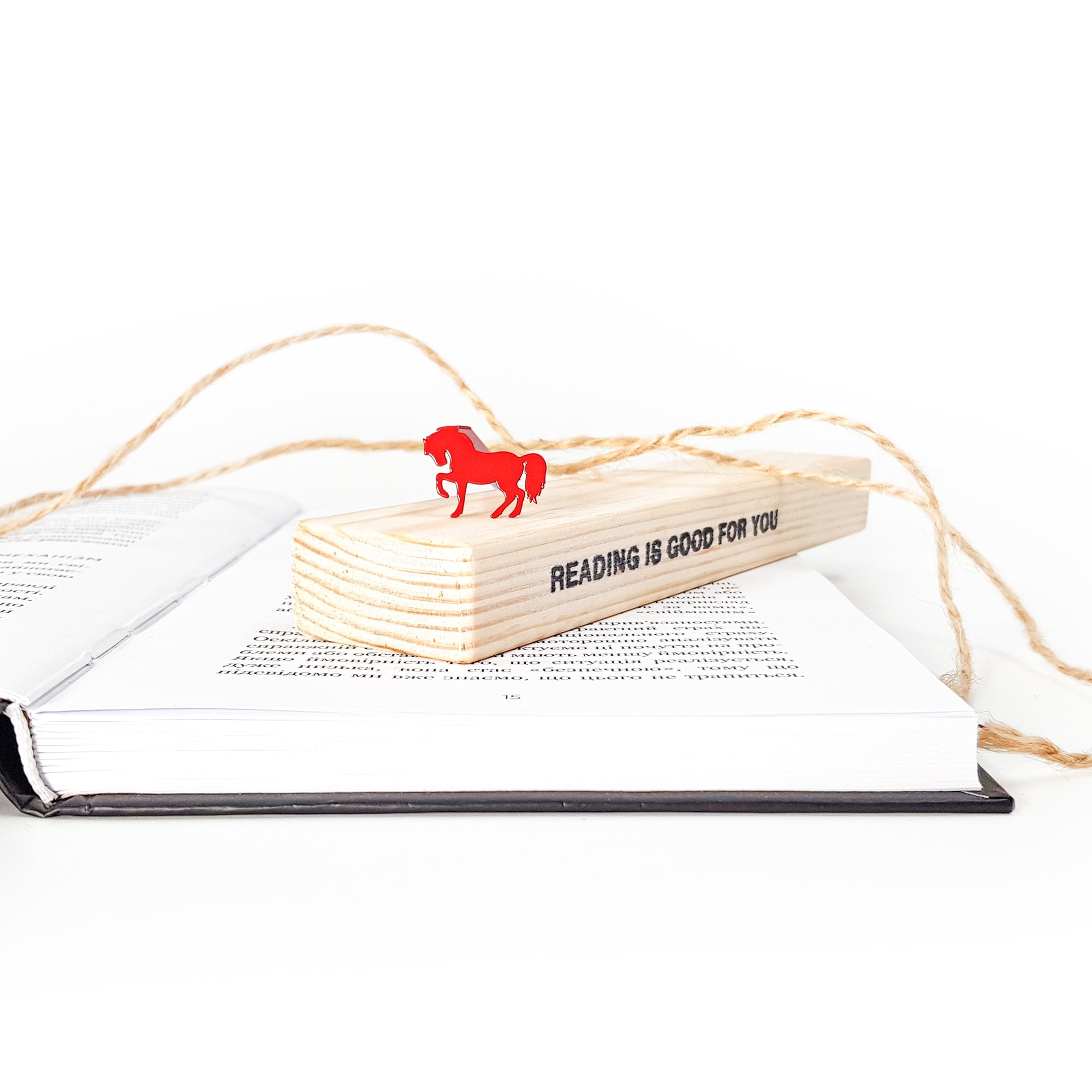 Red horse bookmark on the wooden packaging block.