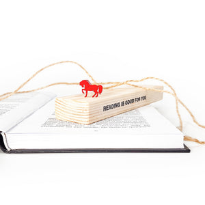 Red horse bookmark on the wooden packaging block.