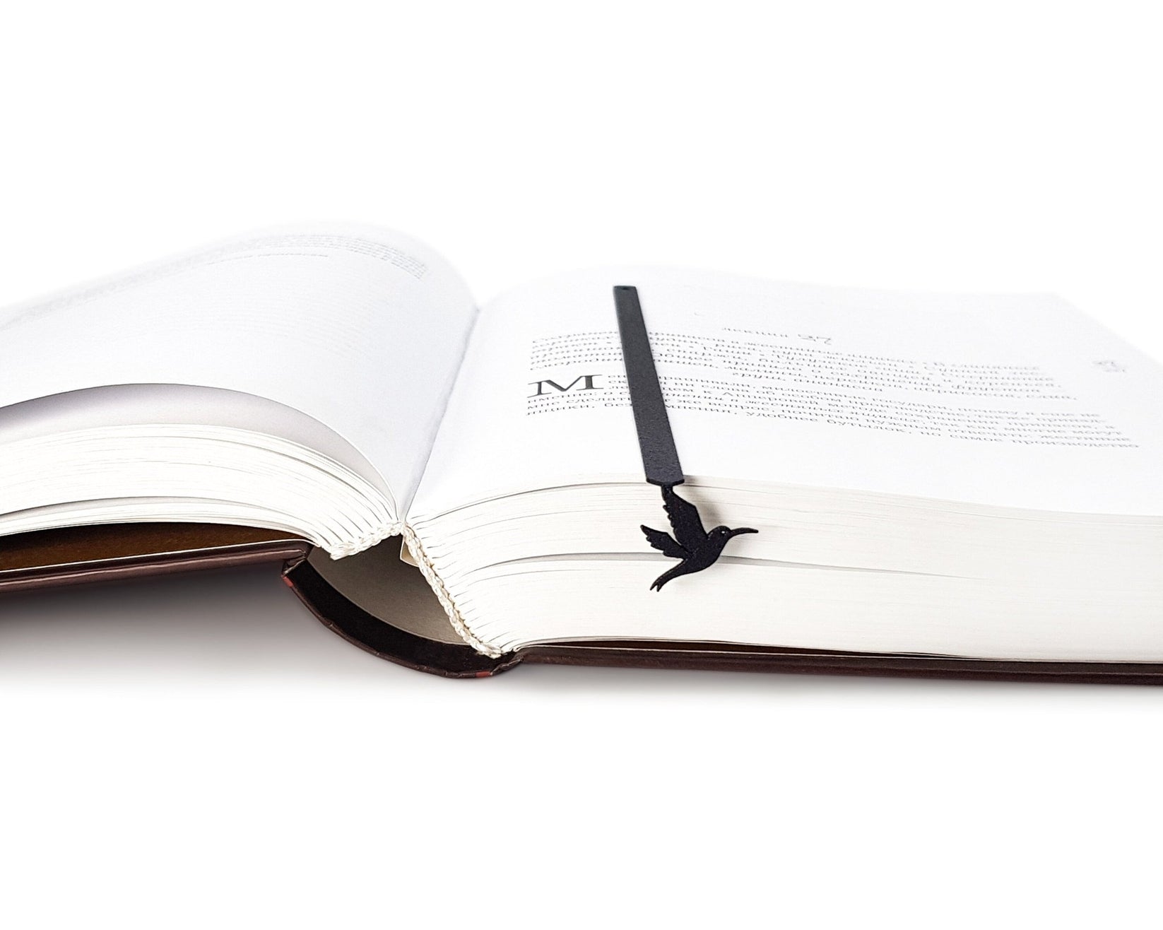 Hummingbird metal bookmark set into the gutter of an open book