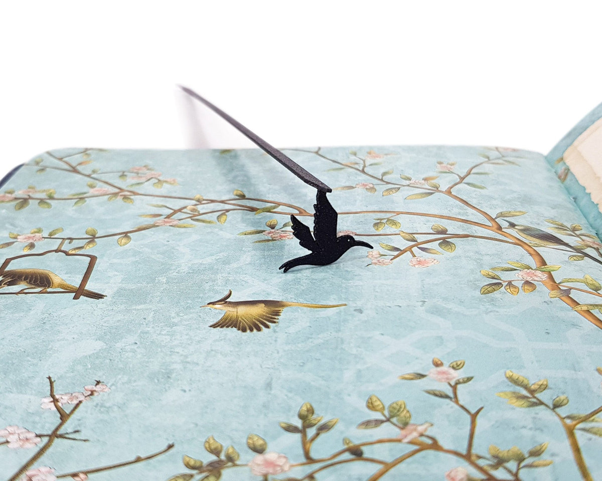 Hummingbird metal bookmark on a coloured background