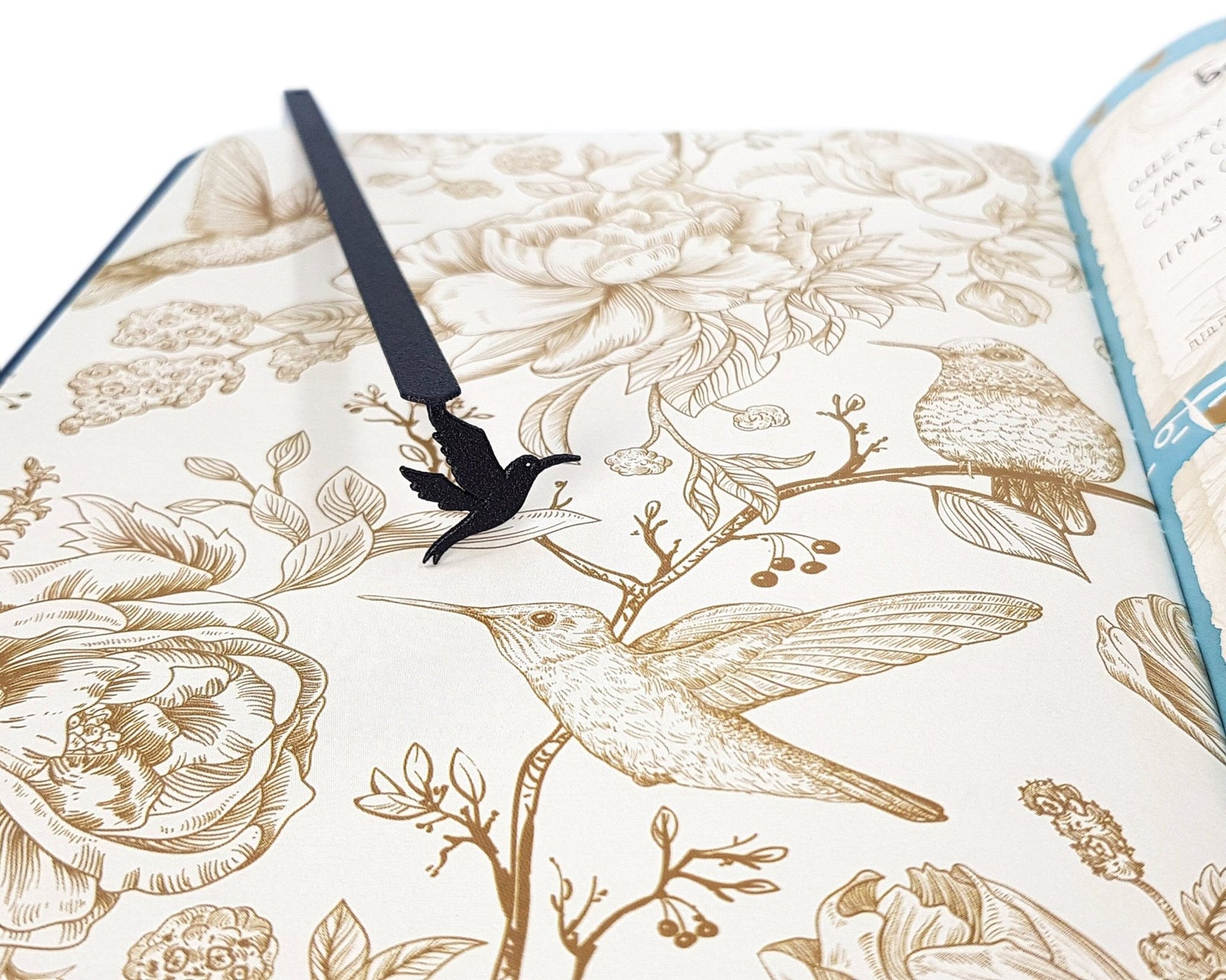 Hummingbird metal bookmark placed on a colour illustration