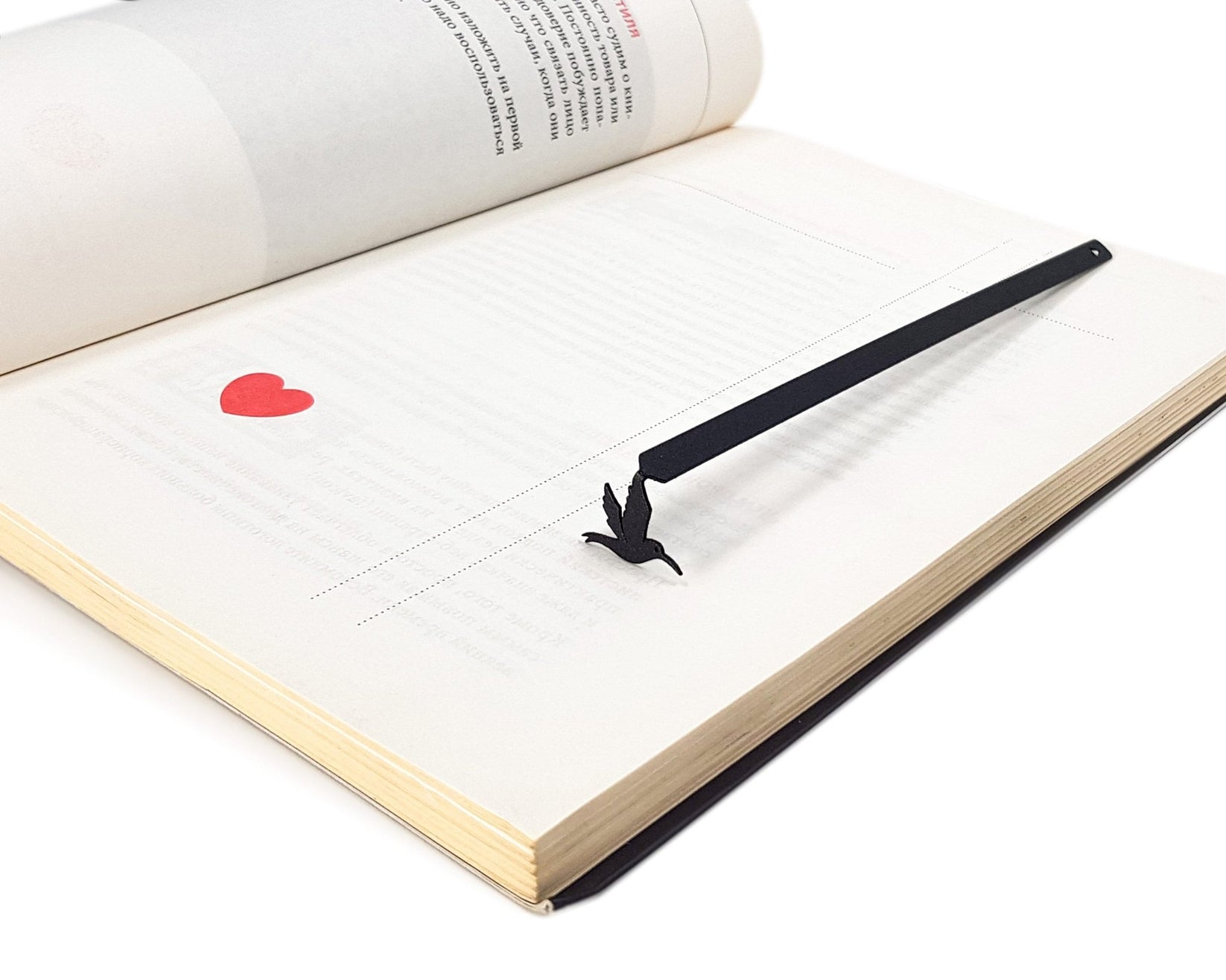 Hummingbird metal bookmark resting on the pages of an open book