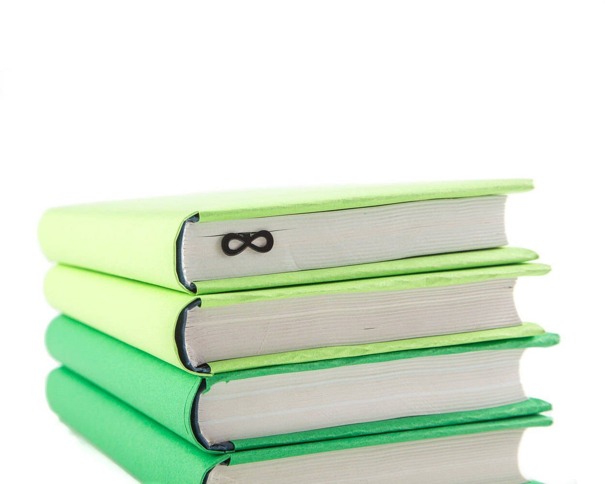 Infinity metal bookmark shown with a stack of books