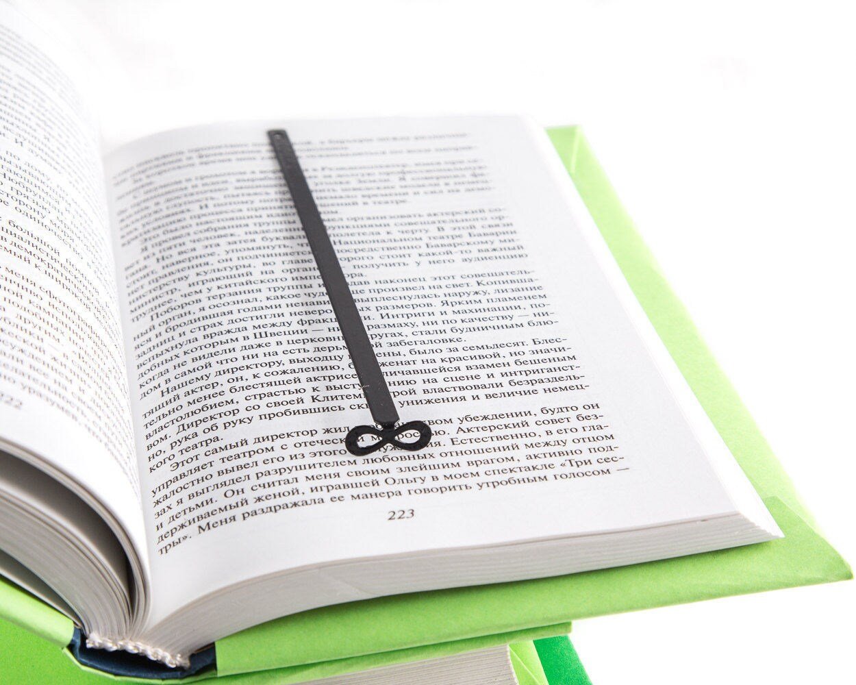 Infinity metal bookmark resting on the pages of an open book