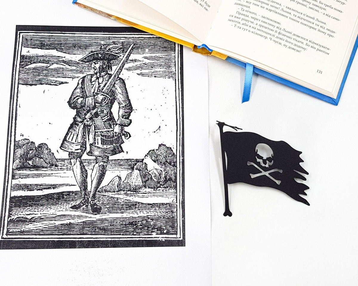 Jolly Rogers metal bookmark placed on a colour illustration