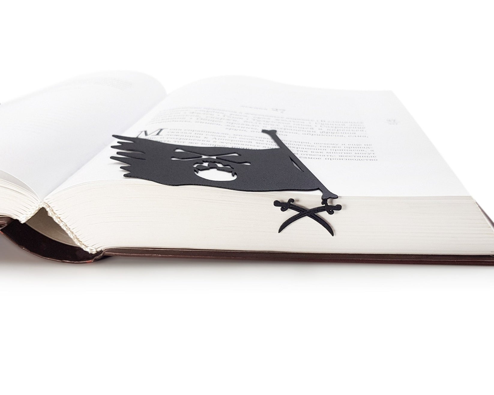 Jolly Rogers metal bookmark in a closed book, only its top showing above the pages