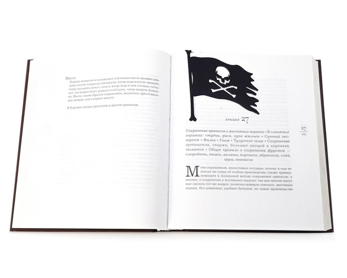Jolly Rogers metal bookmark marking a page in an open book