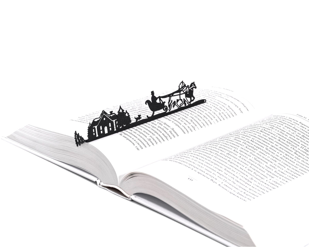 Winter Sleigh Ride metal bookmark marking a page in an open book