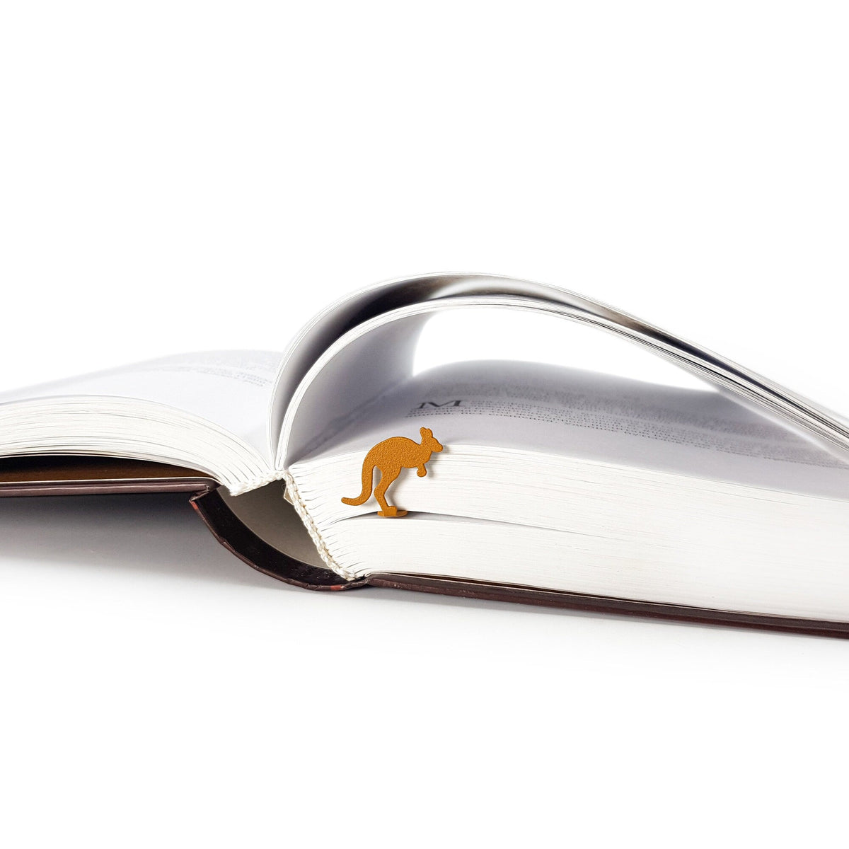 Kangaroo metal bookmark in gold set into the gutter of an open book