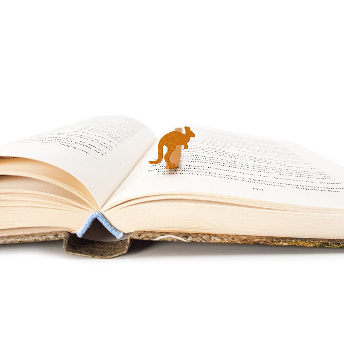 Kangaroo metal bookmark in gold resting on the pages of an open book