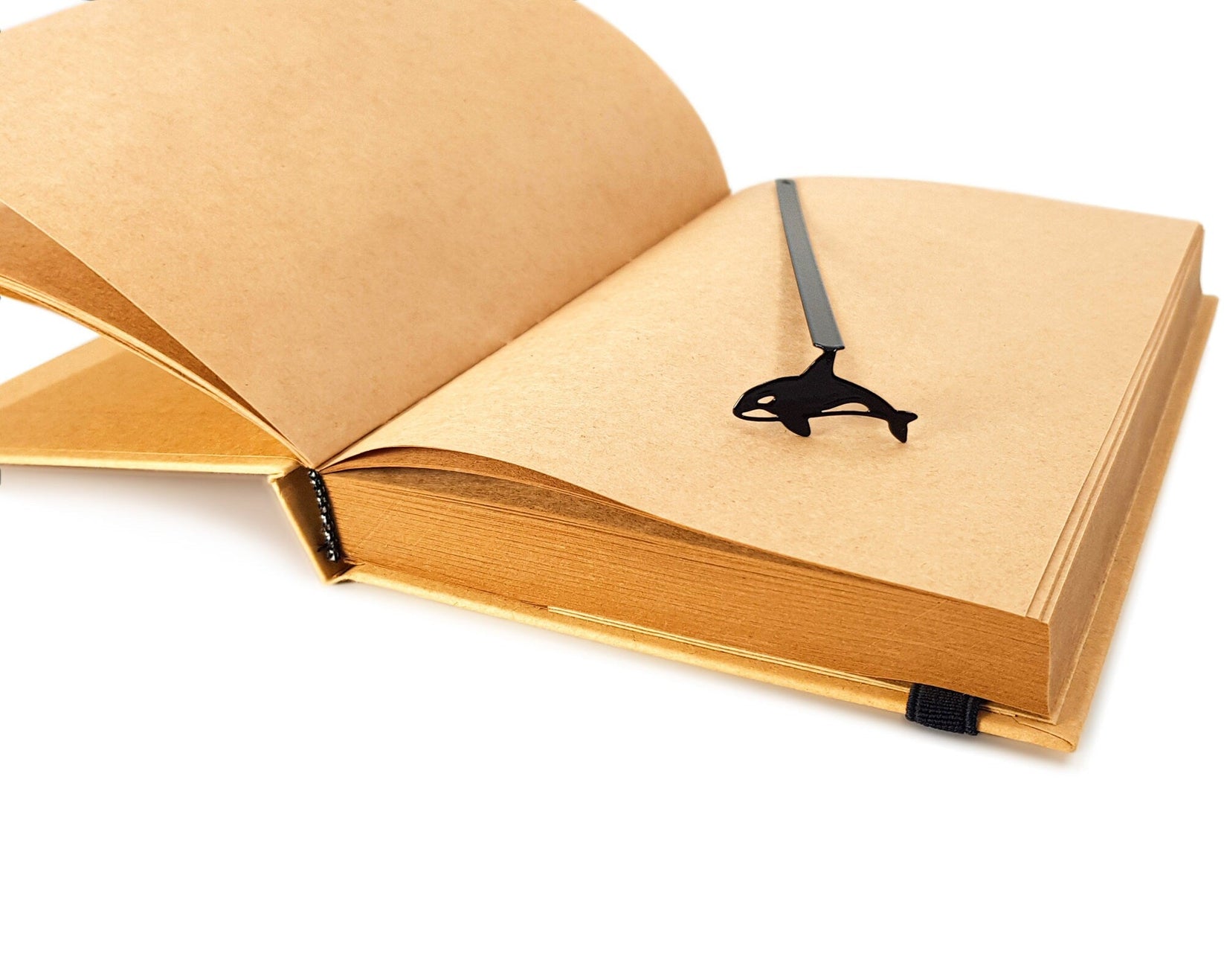 Killer Whale Orca metal bookmark resting on the pages of an open book