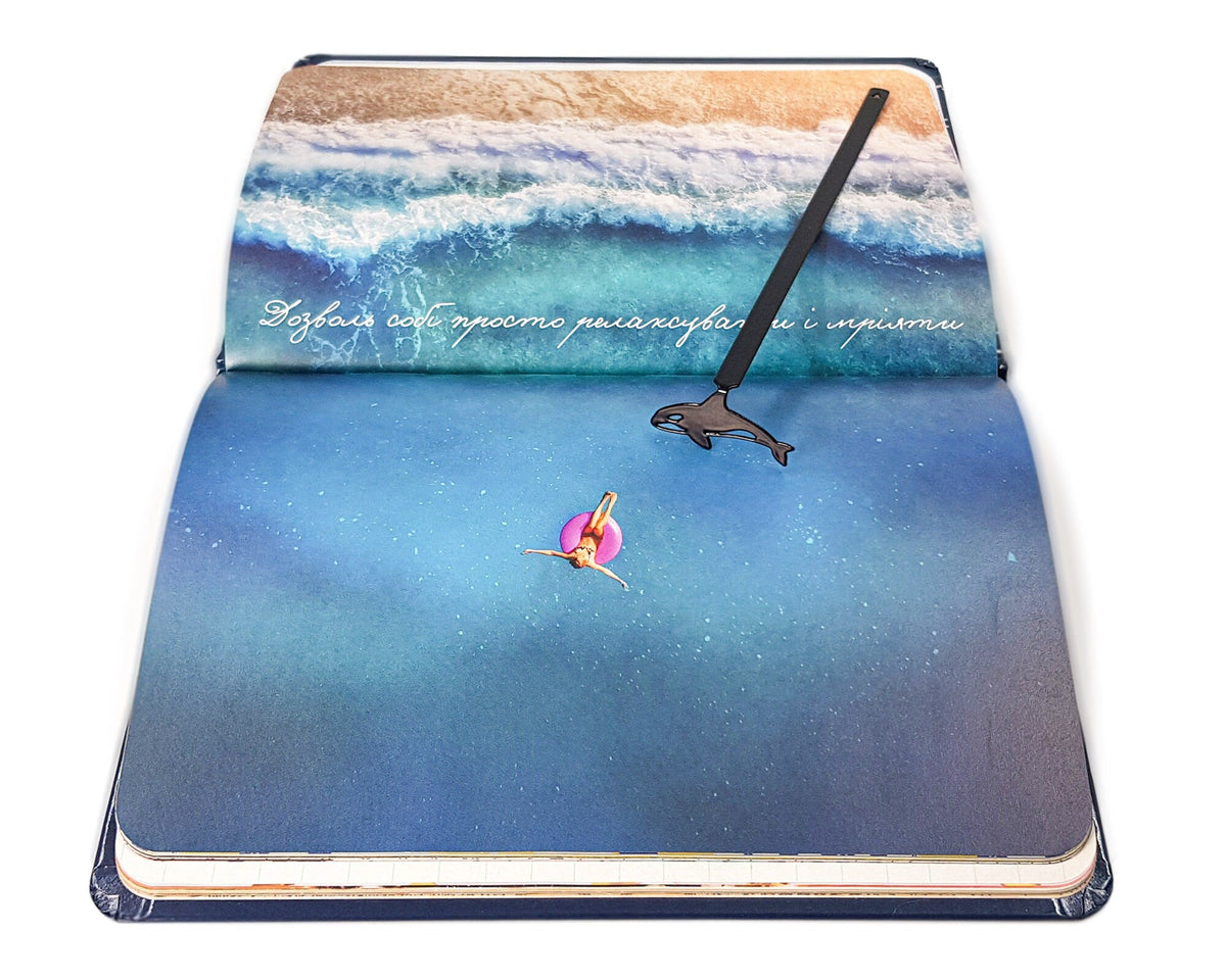 Killer Whale Orca metal bookmark placed on a colour illustration