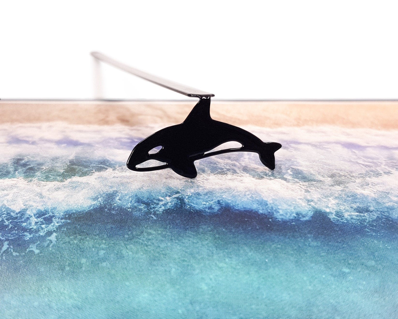 Killer Whale Orca metal bookmark marking a page in an illustrated book