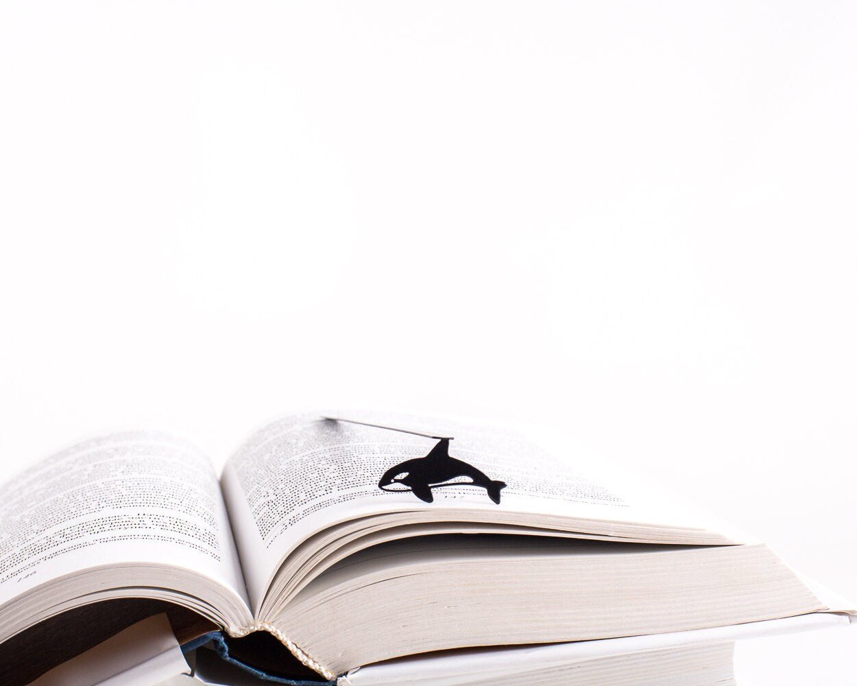 Killer Whale Orca metal bookmark marking a page in an open book