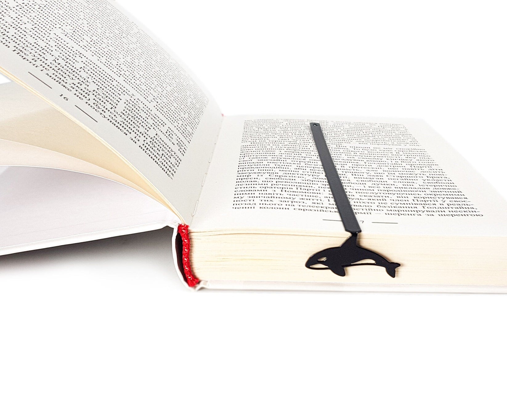 Killer Whale Orca metal bookmark lying across the pages of an open book