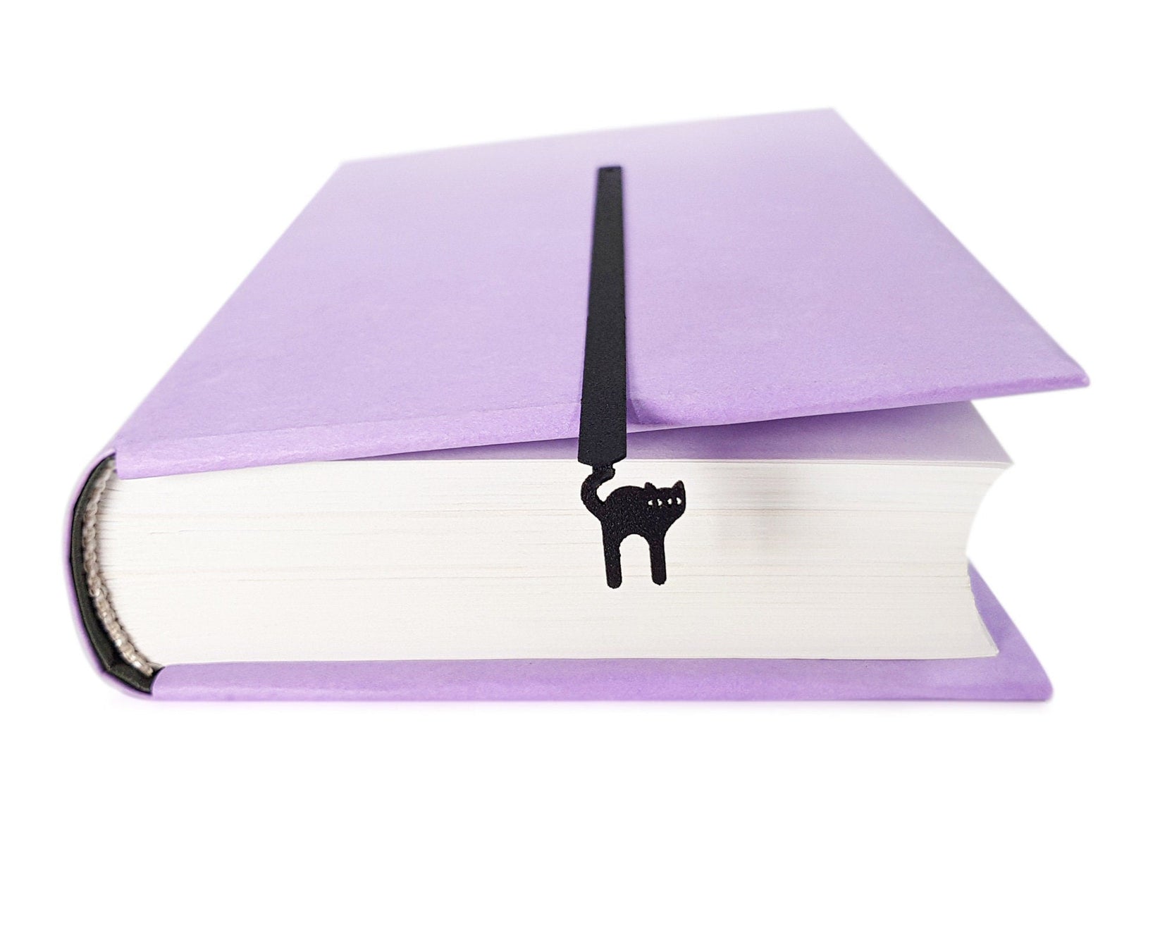 Kitty Grace metal bookmark seen from the edge of a closed book