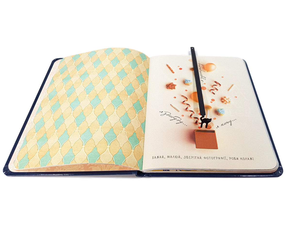 Kitty Grace metal bookmark marking a page in a notebook