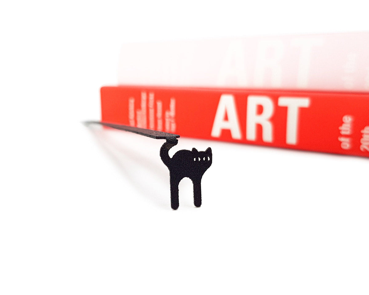 Kitty Grace metal bookmark in a closed book, only its top showing above the pages
