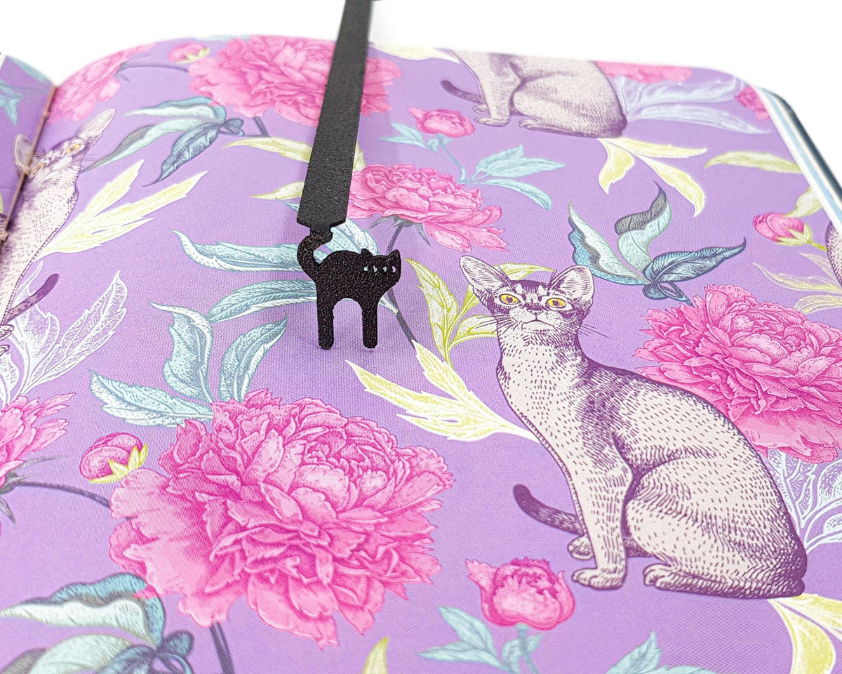 Kitty Grace metal bookmark on a coloured background