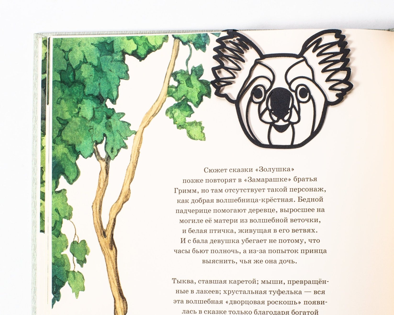 Koala metal bookmark marking a page in an illustrated book