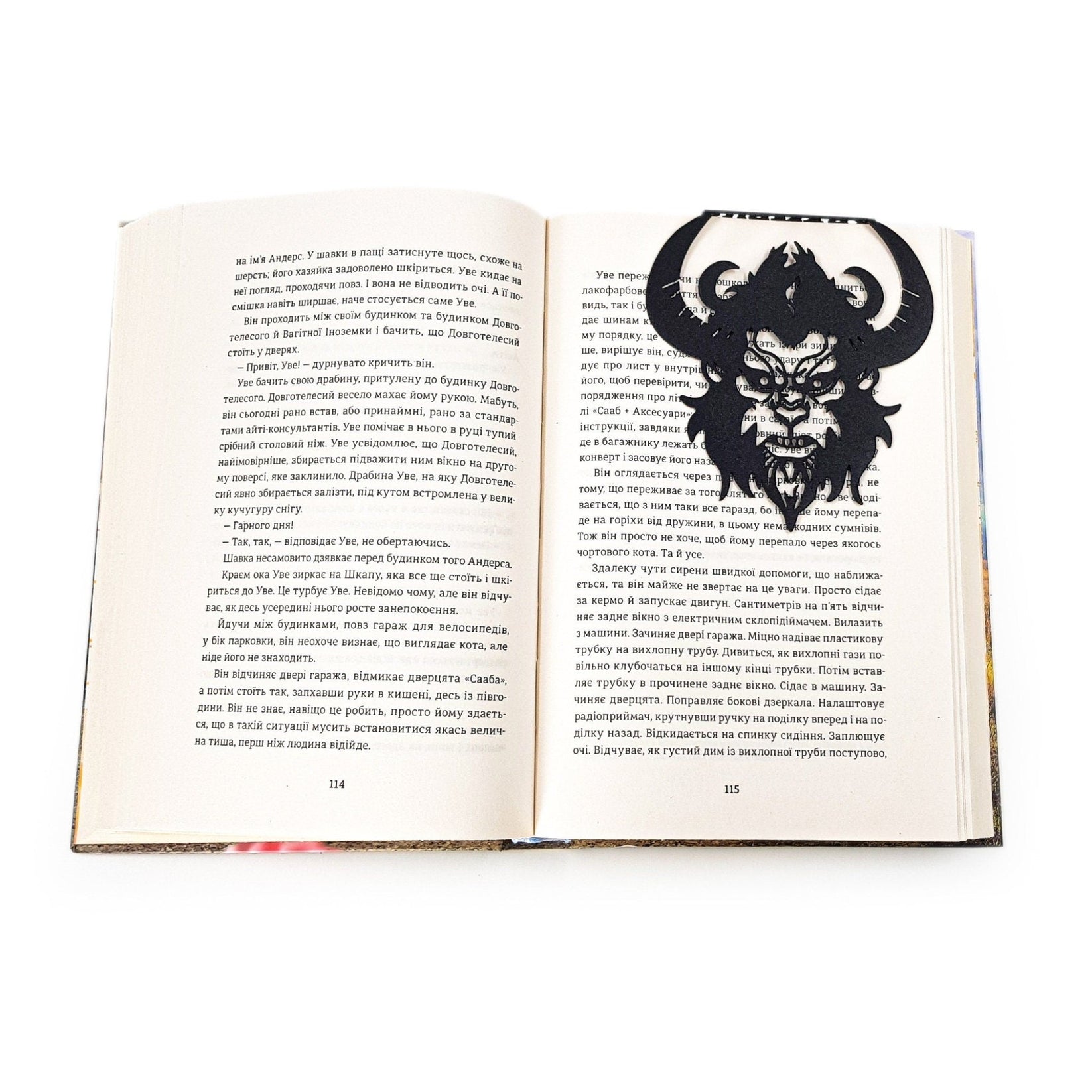 Krampus metal bookmark resting on the pages of an open book