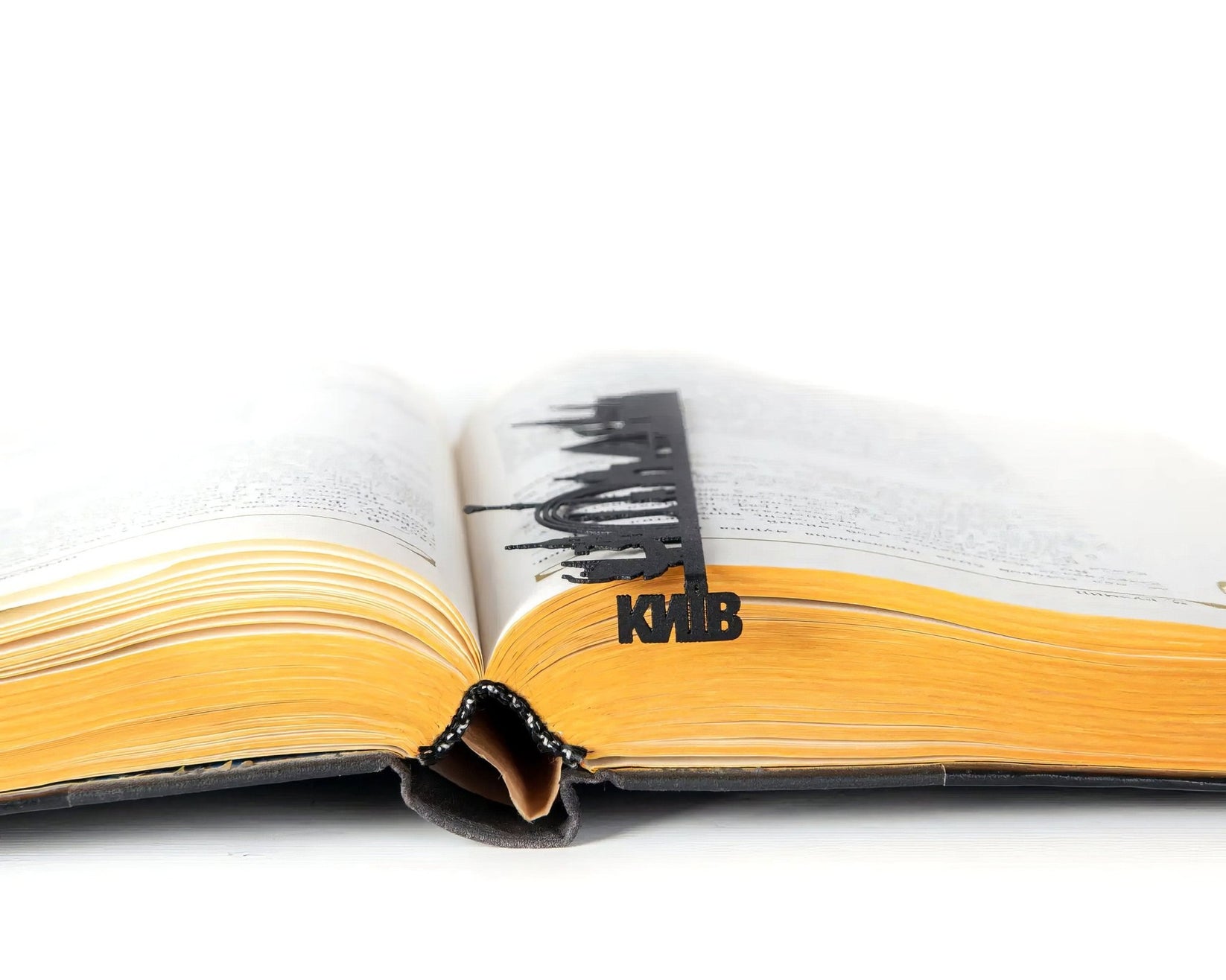 Kyiv Cityscape metal bookmark marking a page in an open book