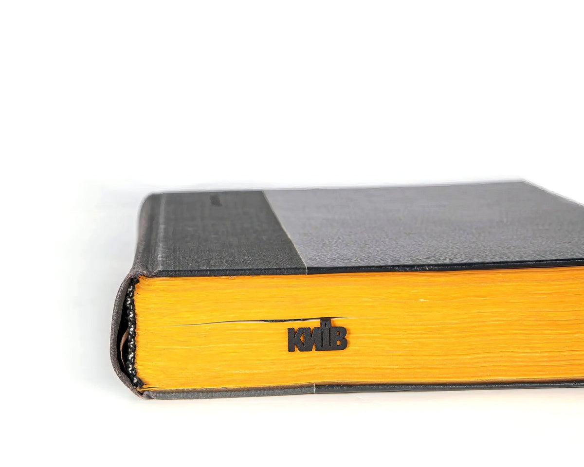 Kyiv Cityscape metal bookmark in a closed book, only its top showing above the pages