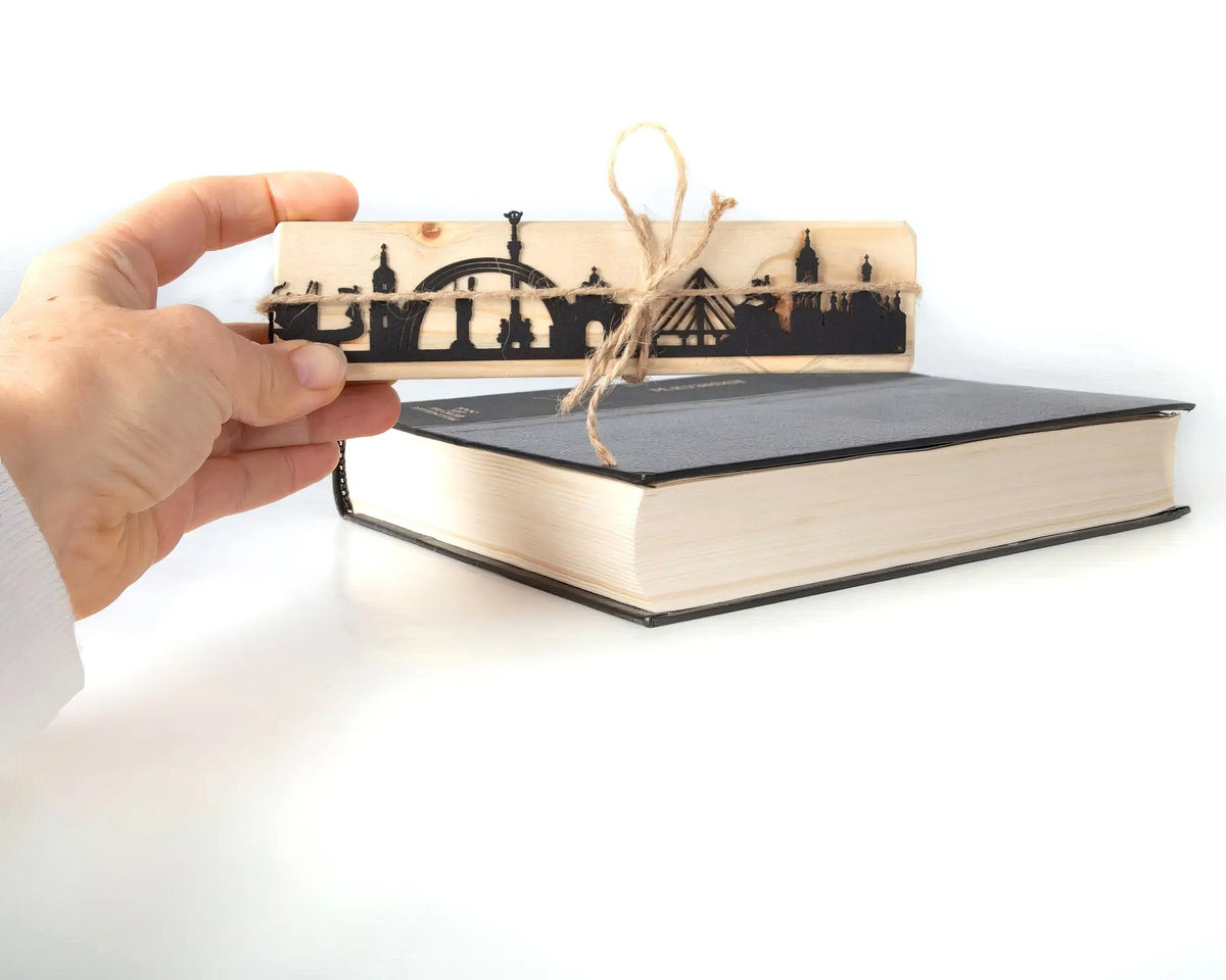 Kyiv Cityscape metal bookmark held in a hand above an open book