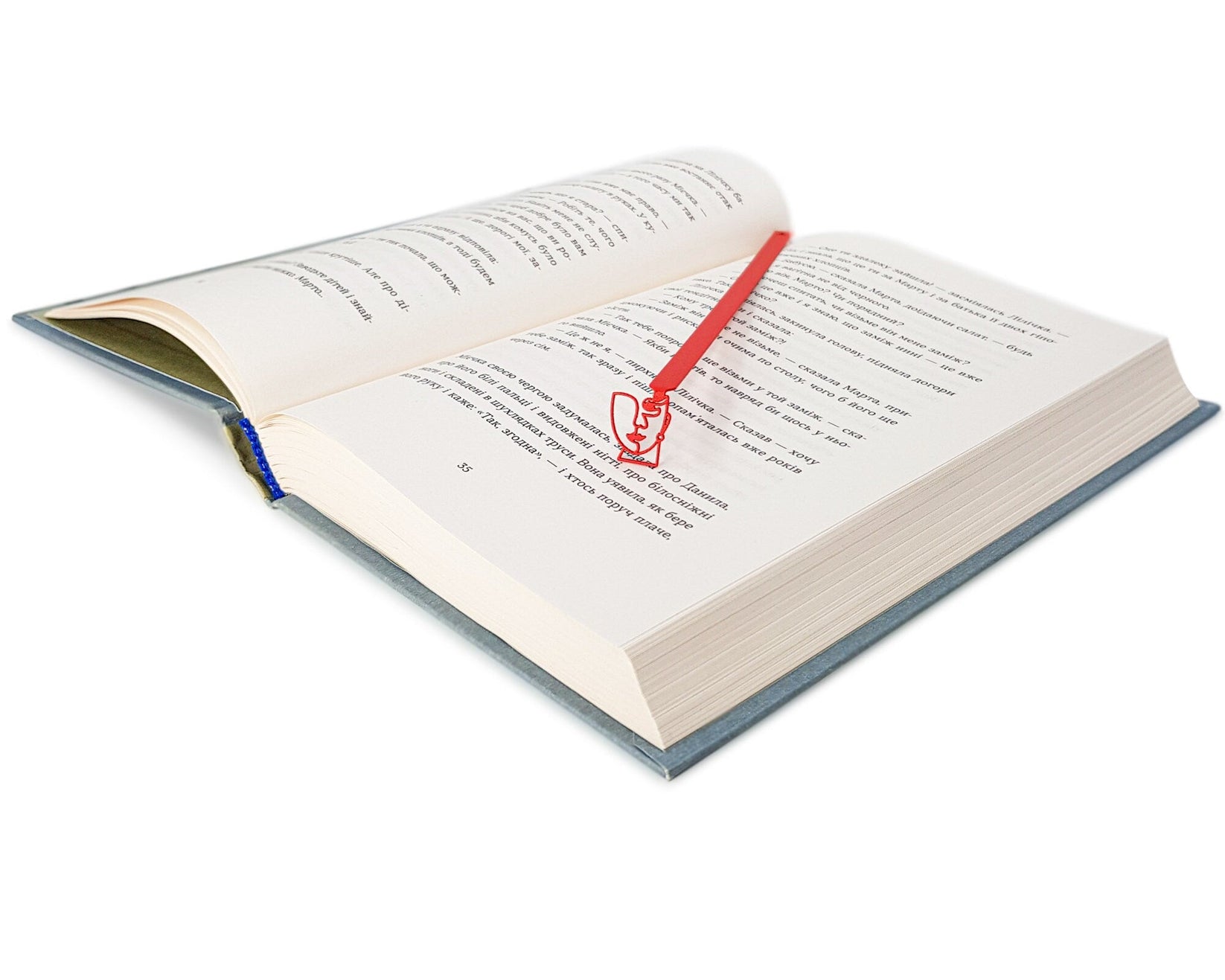 Lady in Red metal bookmark in red marking a page in an open book