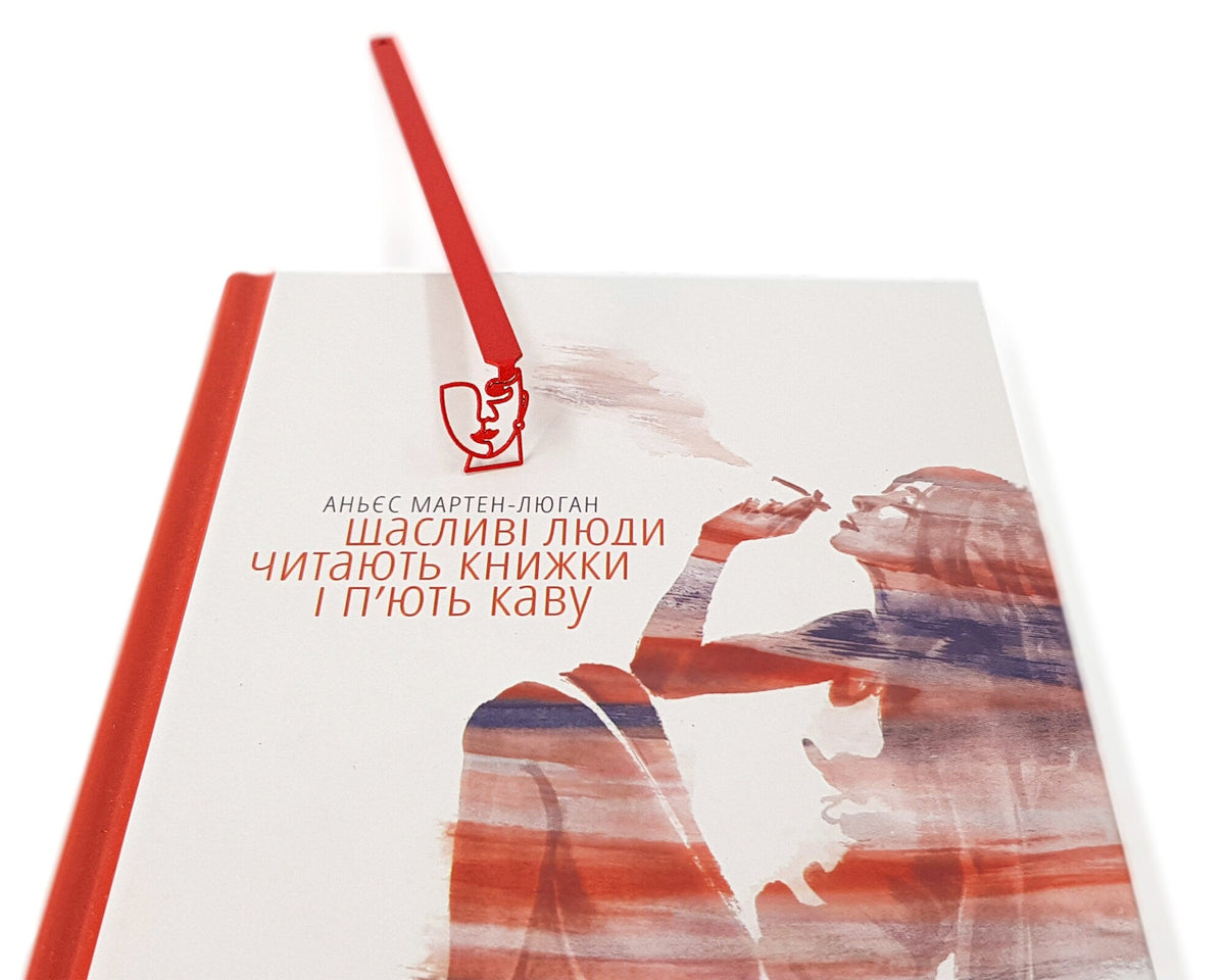 Lady in Red metal bookmark in red marking a page in an illustrated book