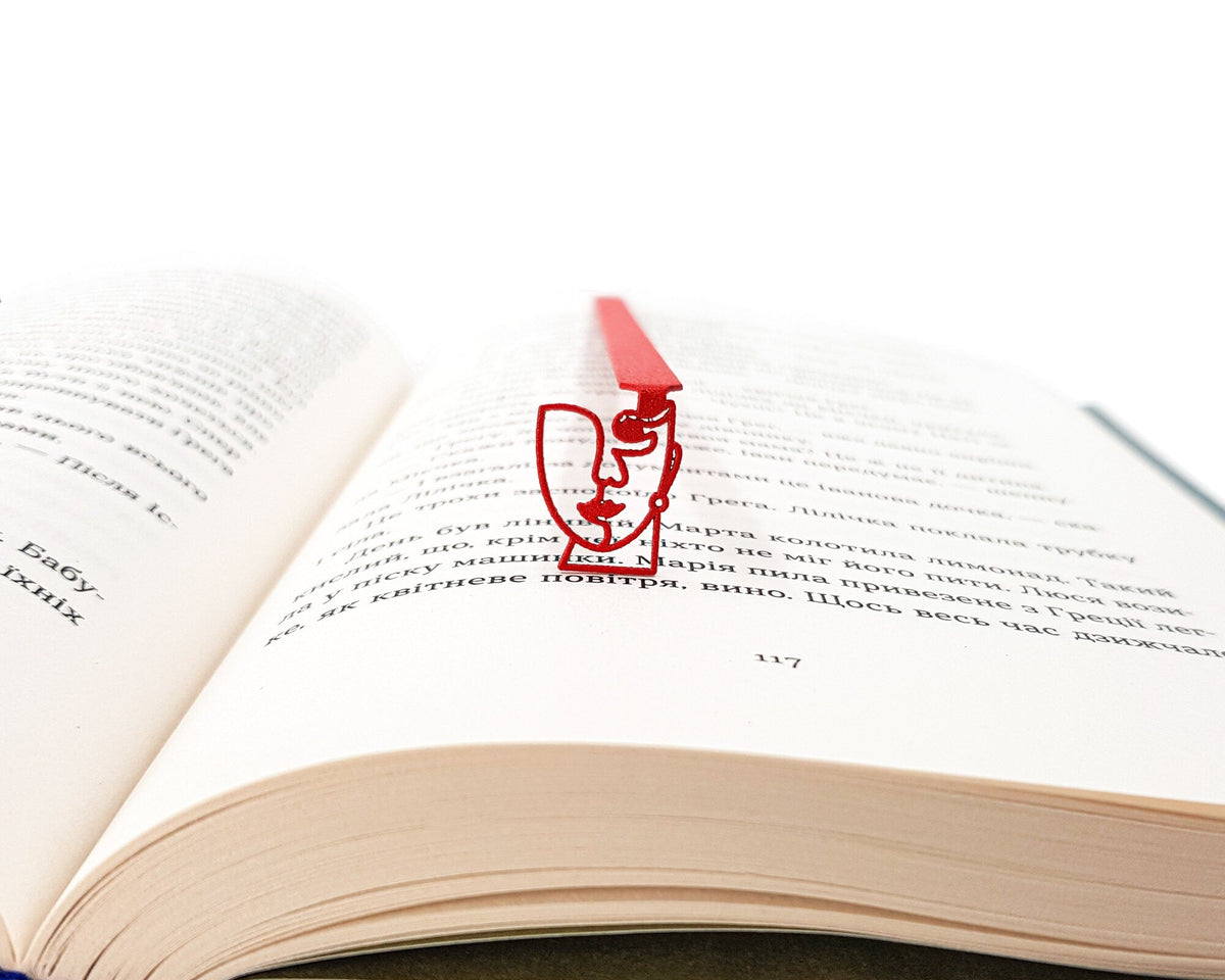 Lady in Red metal bookmark in red lying across the pages of an open book