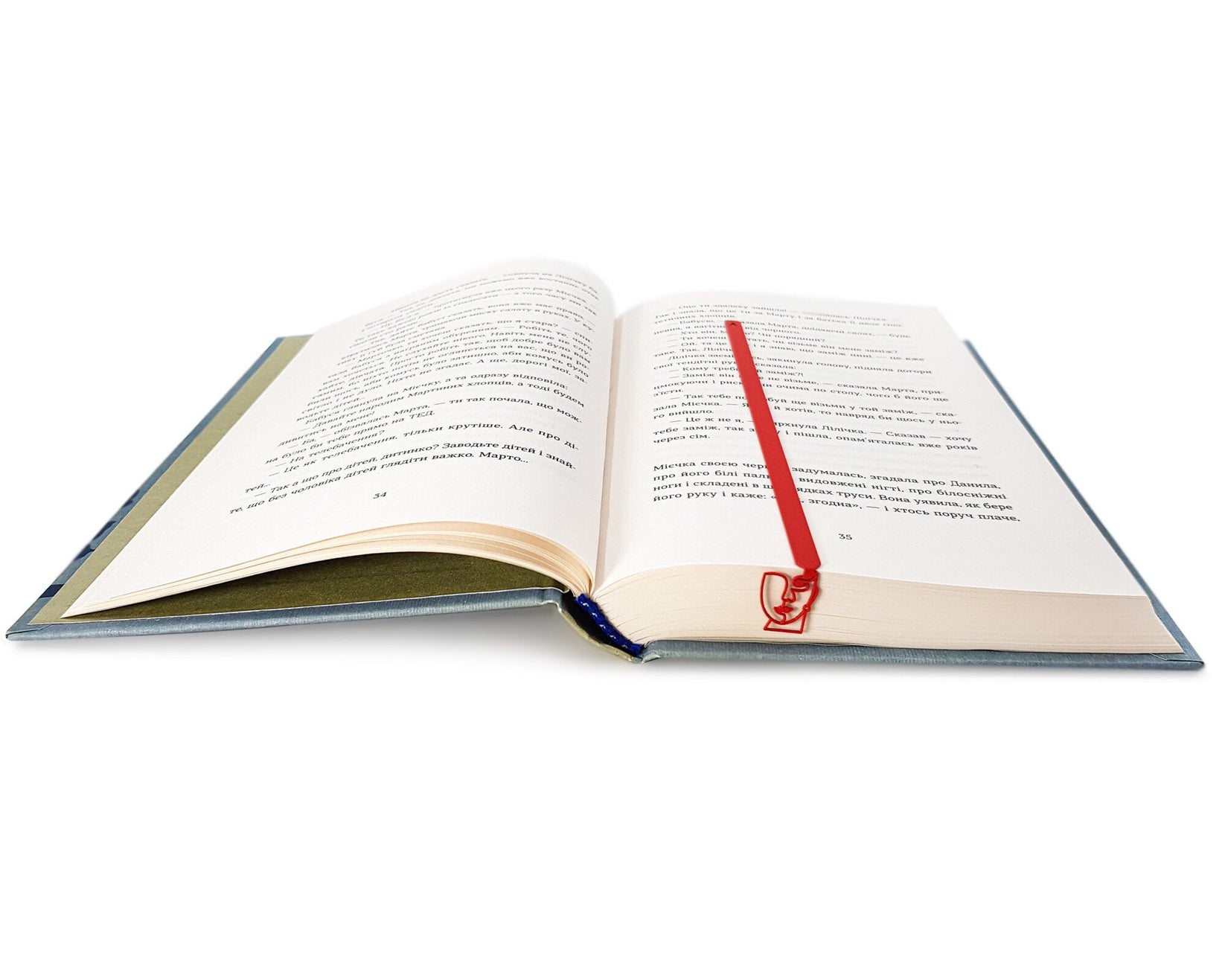 Lady in Red metal bookmark in red resting on the pages of an open book