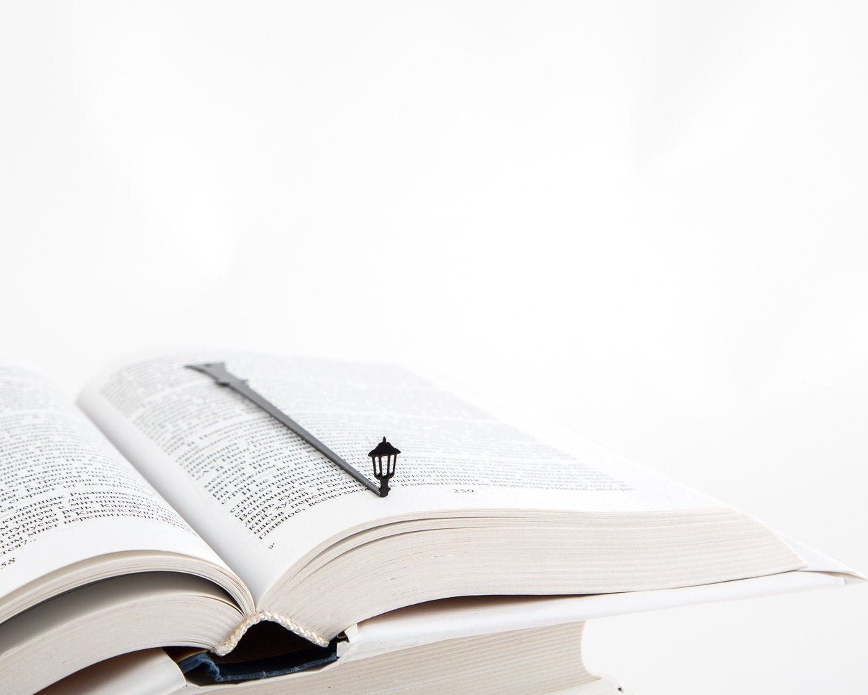Lamppost metal bookmark marking a page in an open book