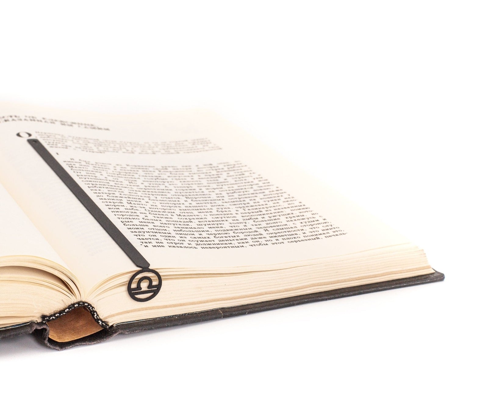 Libra metal bookmark resting on the pages of an open book