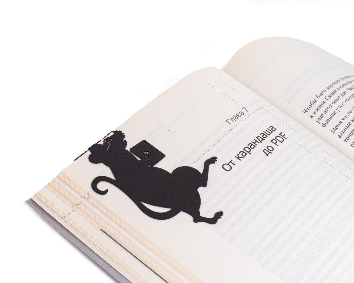 Library Mouse metal bookmark marking a page in an open book