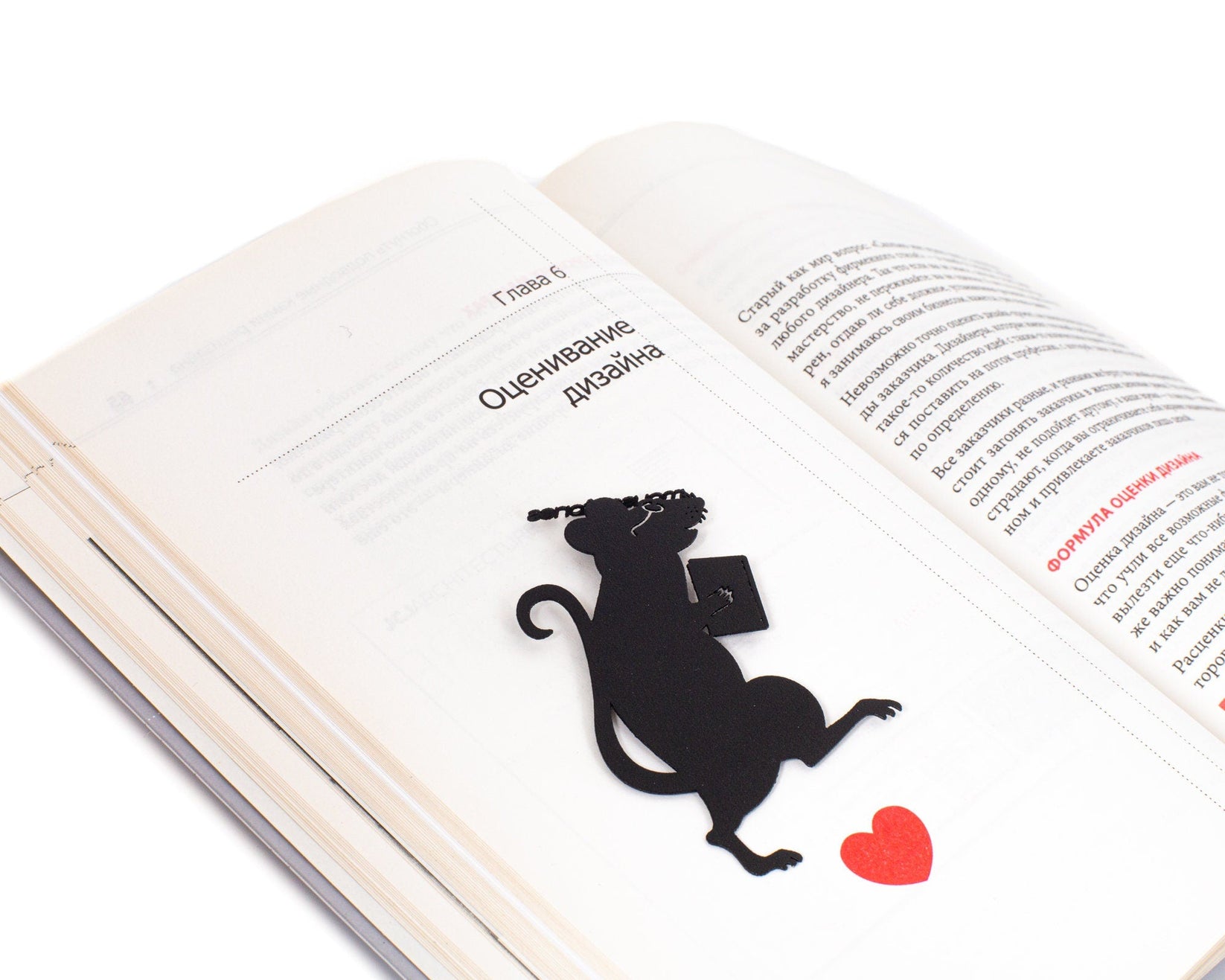 Library Mouse metal bookmark resting on the pages of an open book