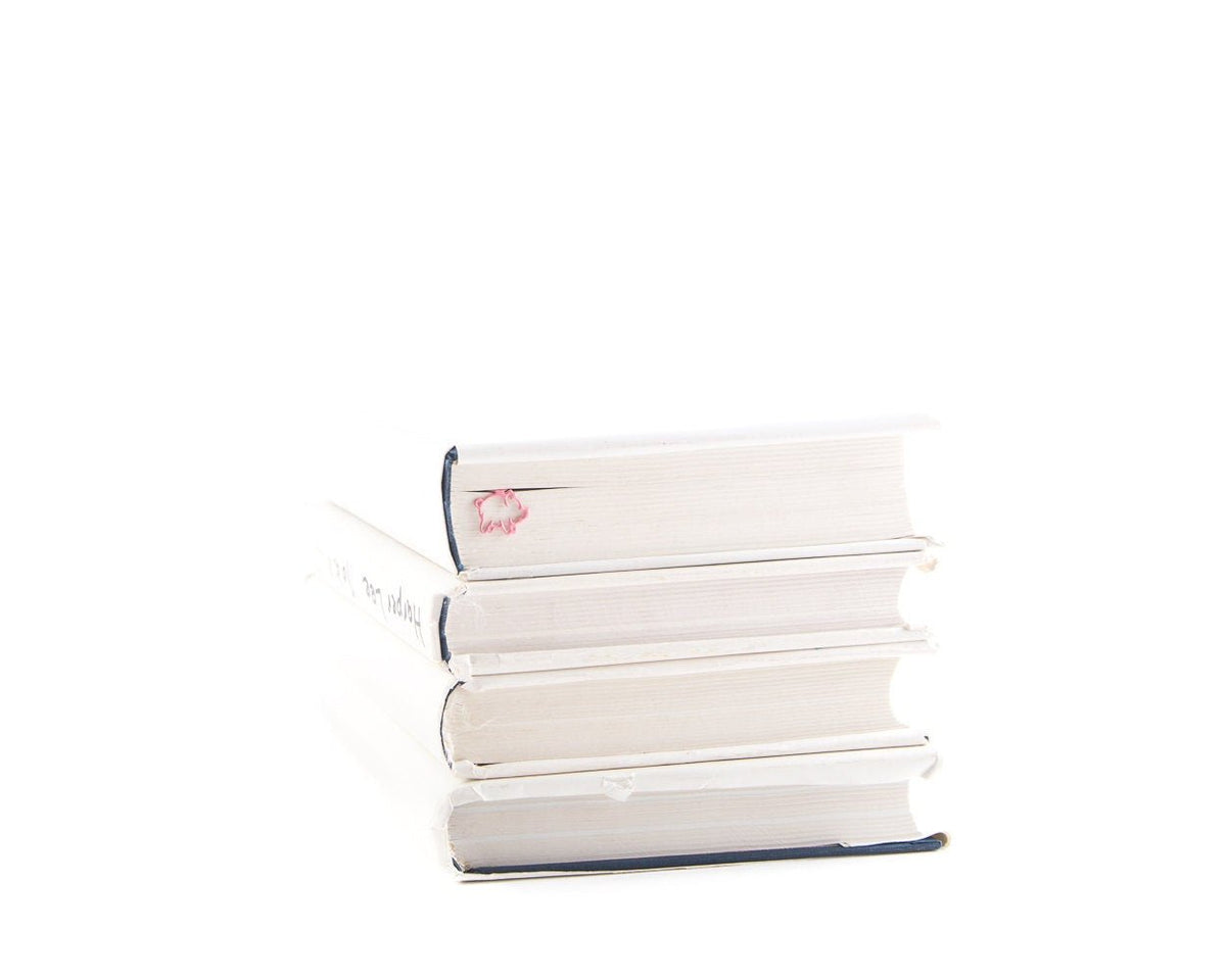 Little Piggy metal bookmark shown with a stack of books