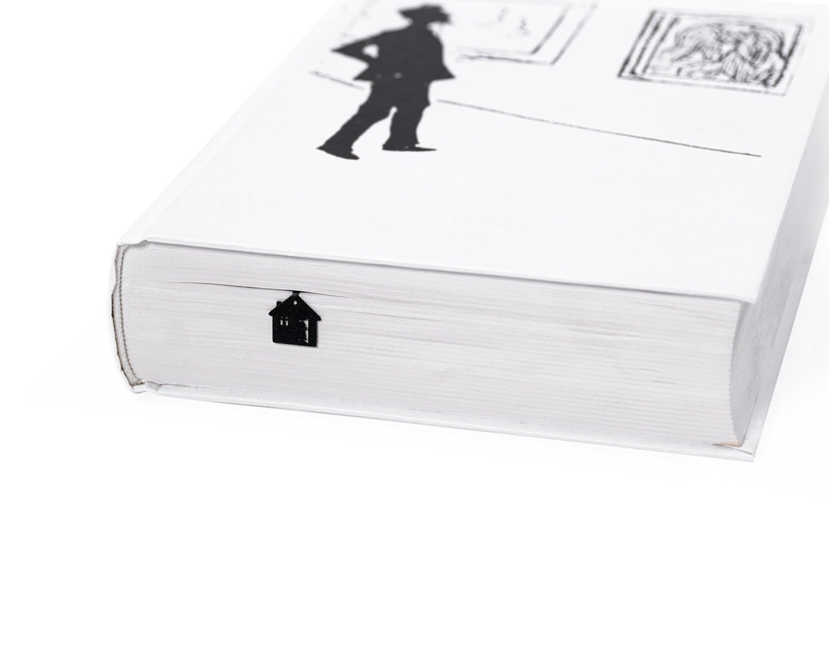 Little Red Riding Hood metal bookmark in a closed book, only its top showing above the pages