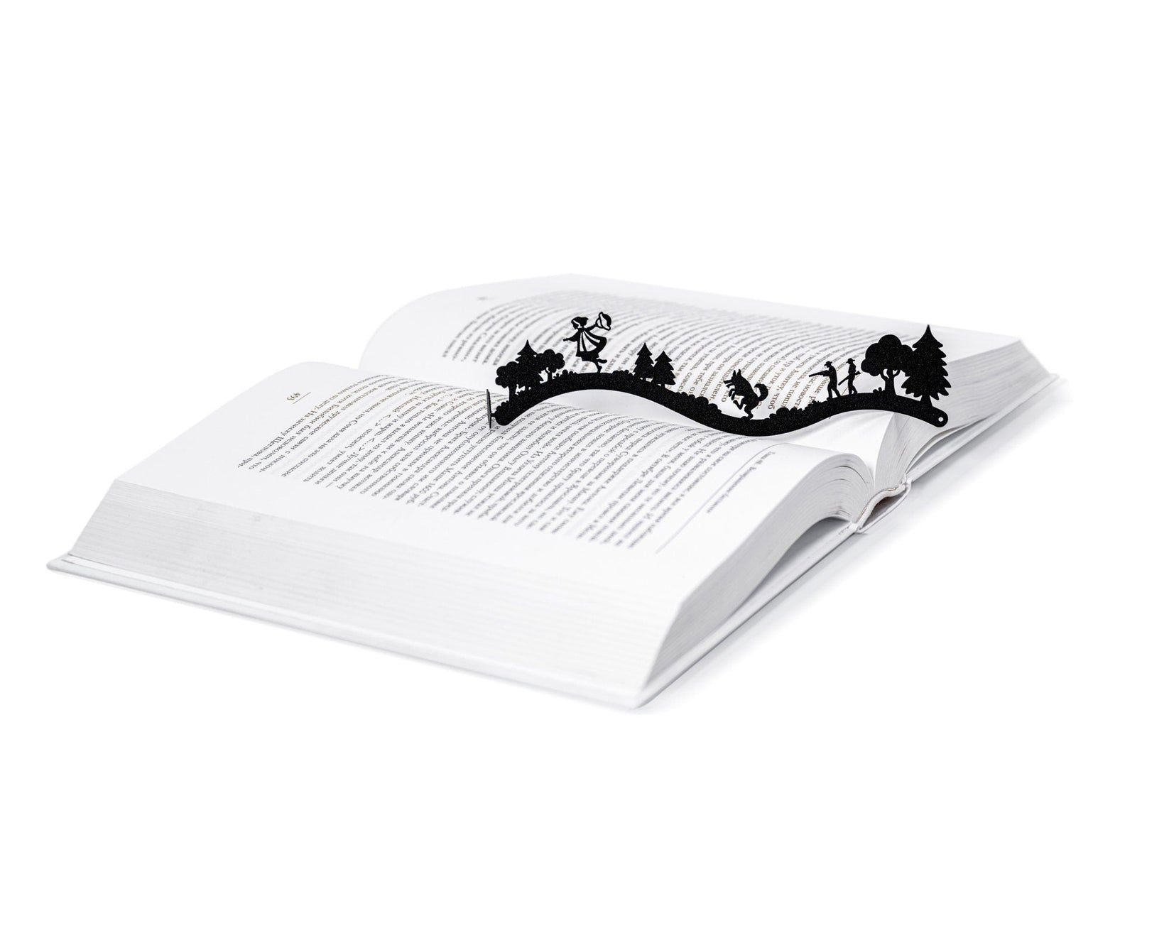 Little Red Riding Hood metal bookmark resting on the pages of an open book