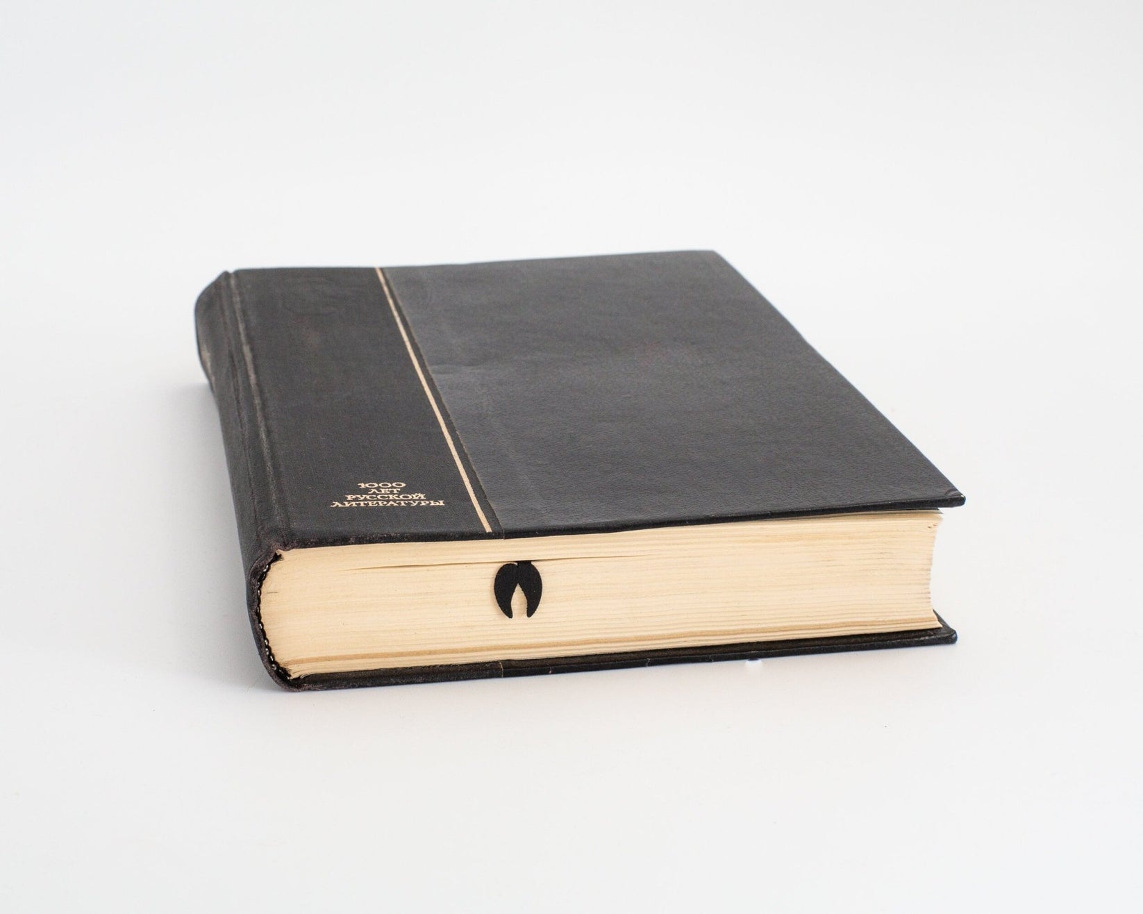 Llama metal bookmark in a closed book, only its top showing above the pages