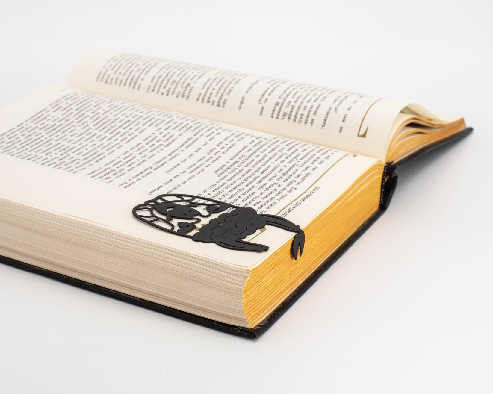Llama metal bookmark resting on the pages of an open book