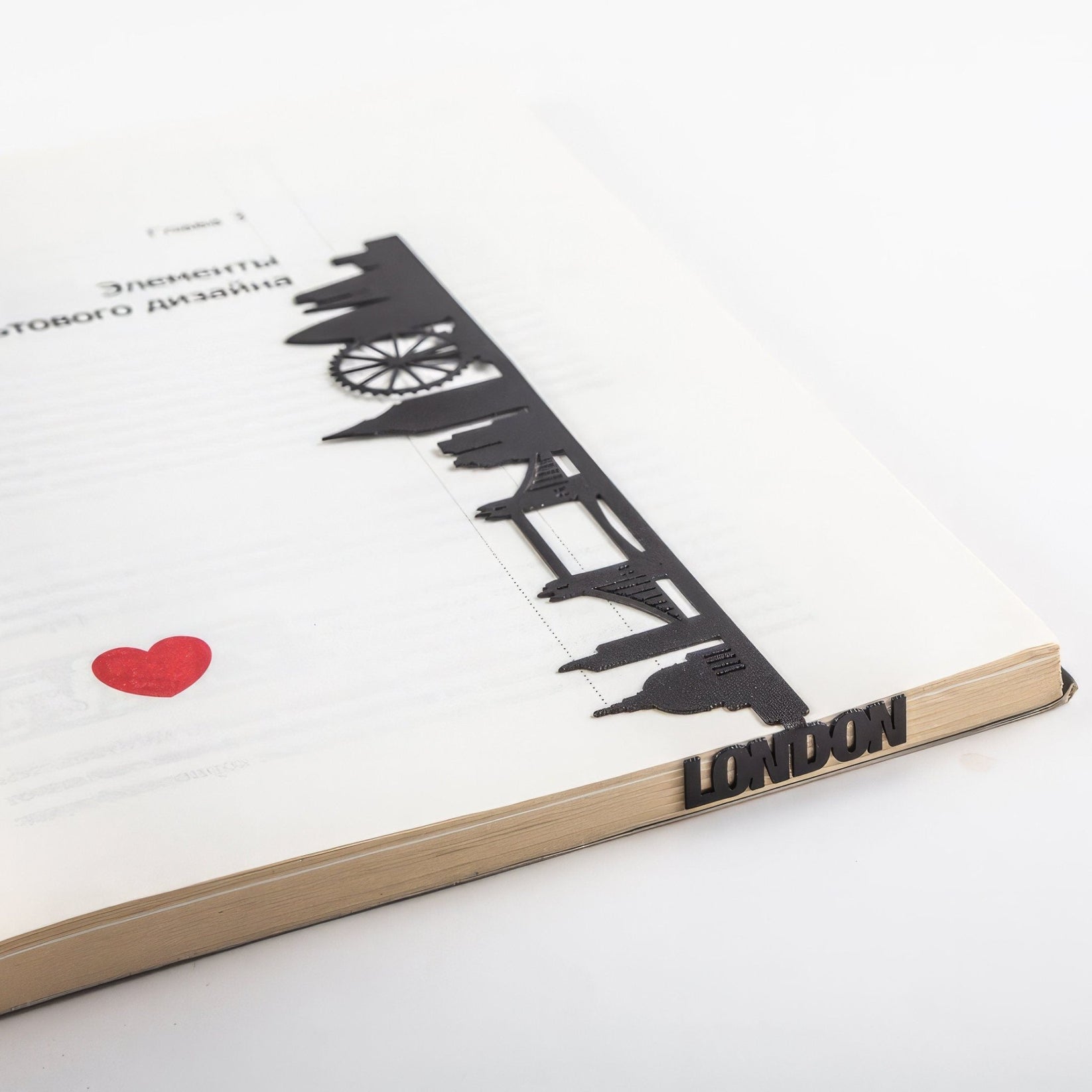 London metal bookmark marking a page in an open book