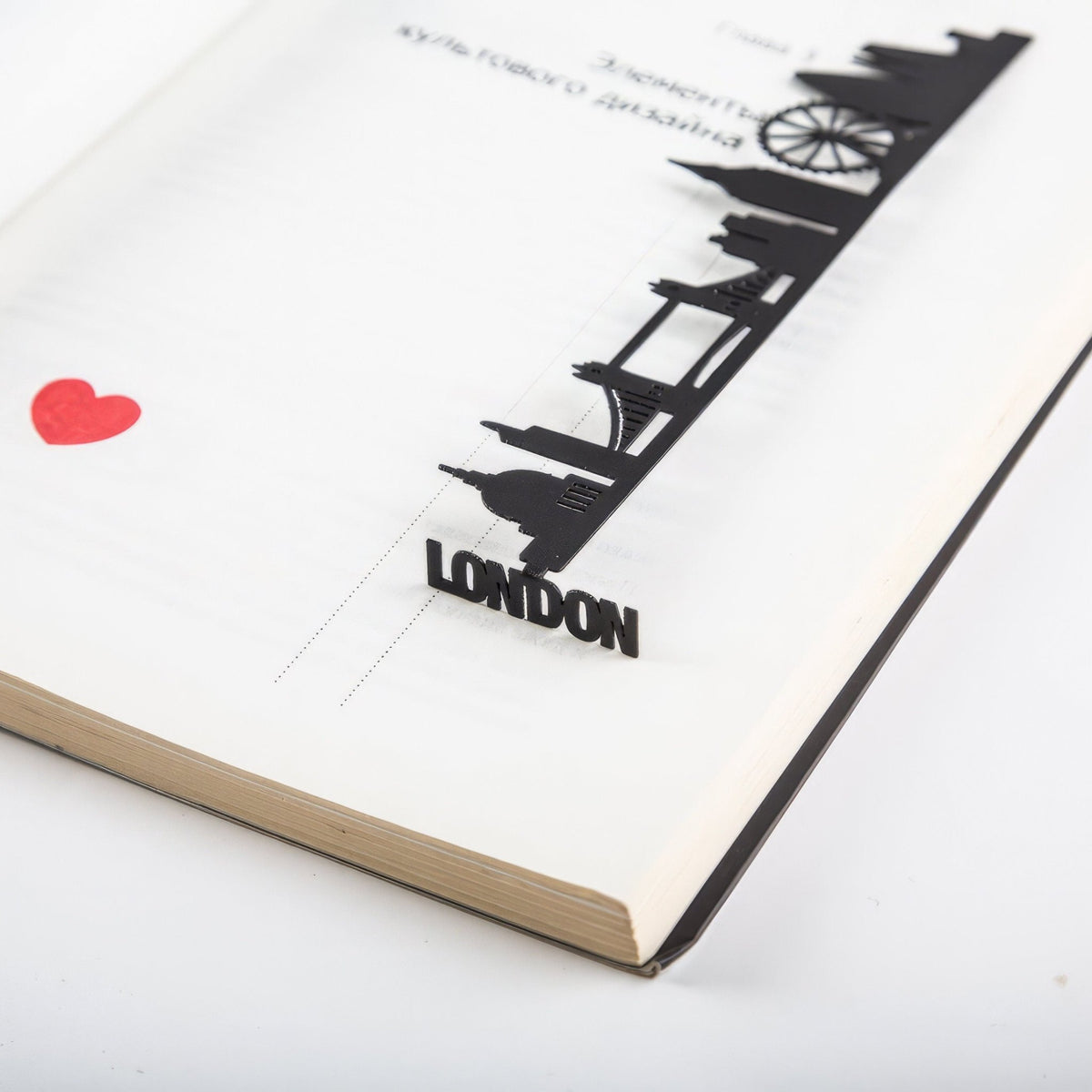 London metal bookmark set into the gutter of an open book