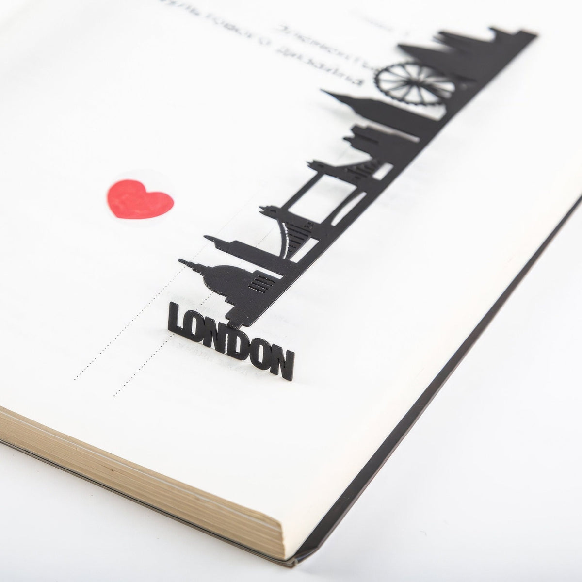 London metal bookmark resting on the pages of an open book